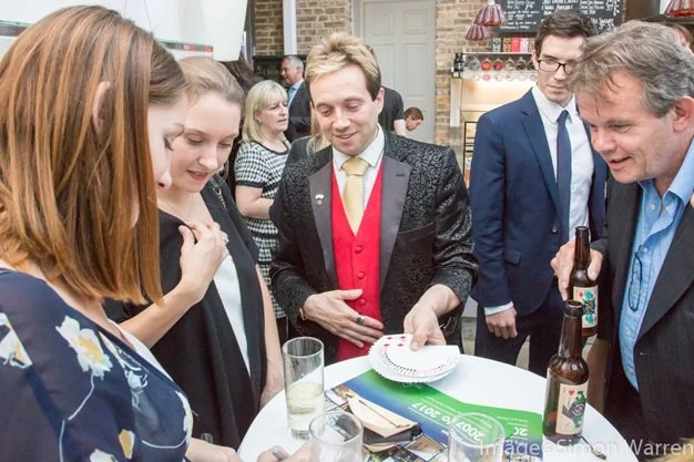 Guests reacting to magician Matthew Garrett at William Morris Gallery Walthamstow London