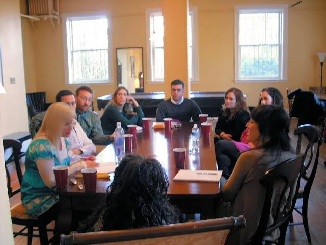 In the Social Room, here's our 1st Story Circle workshop, for our 1st show, Sins of Youth. Clockwise from back of her head: Natalie E. Illum , Alexandra Hewett, Adam Ruben, Dan Gasiewski, Cathy Alter, Shrake, Diane Ivey, Jennifer Tress & This American Life senior producer Jane Feltes , who came down from New York to story-coach us.