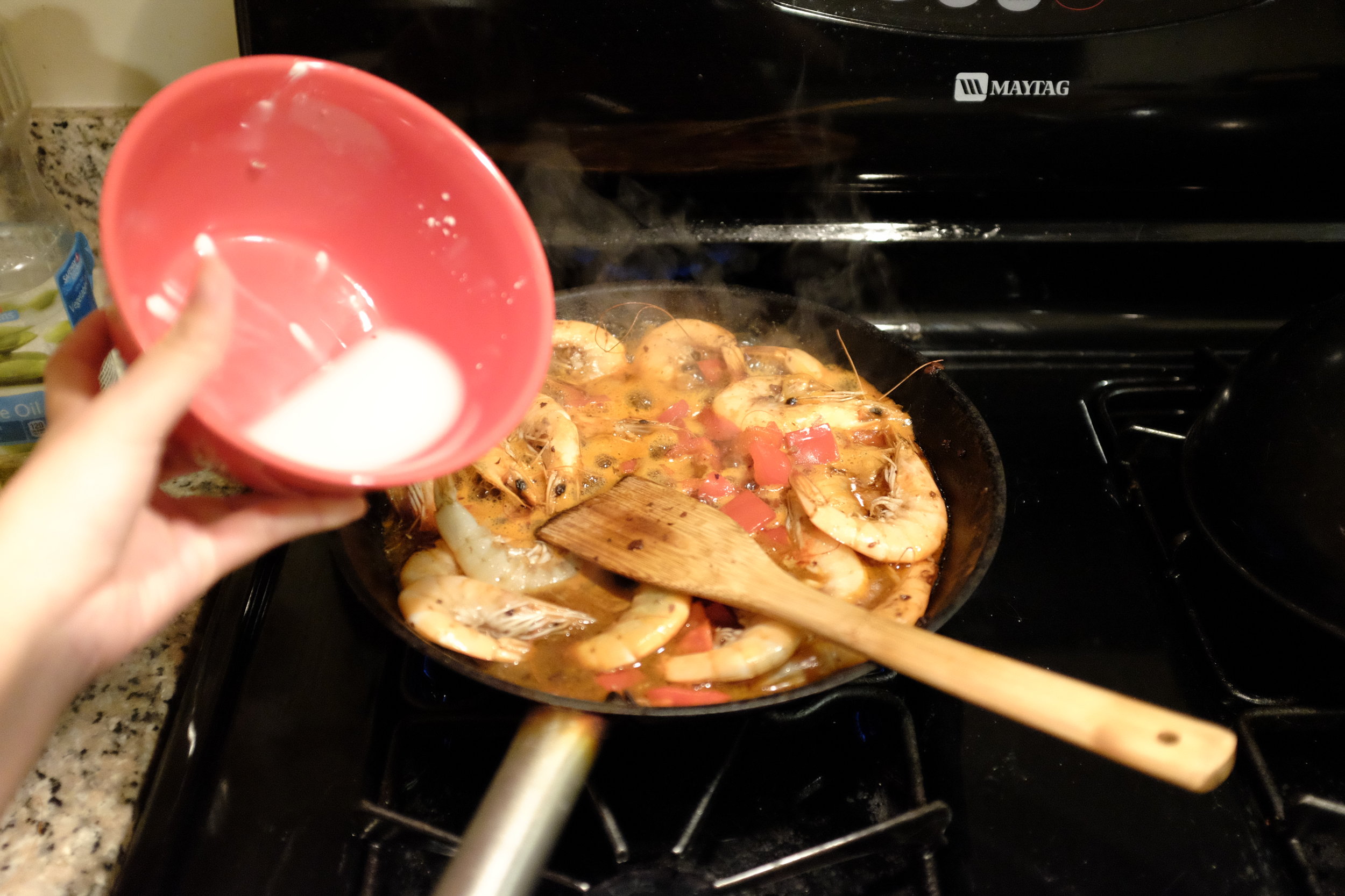 Pouring in the cornstarch mix to thicken the sauce.&nbsp;