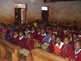 There are often 4 children to one desk at Tloma Primary School