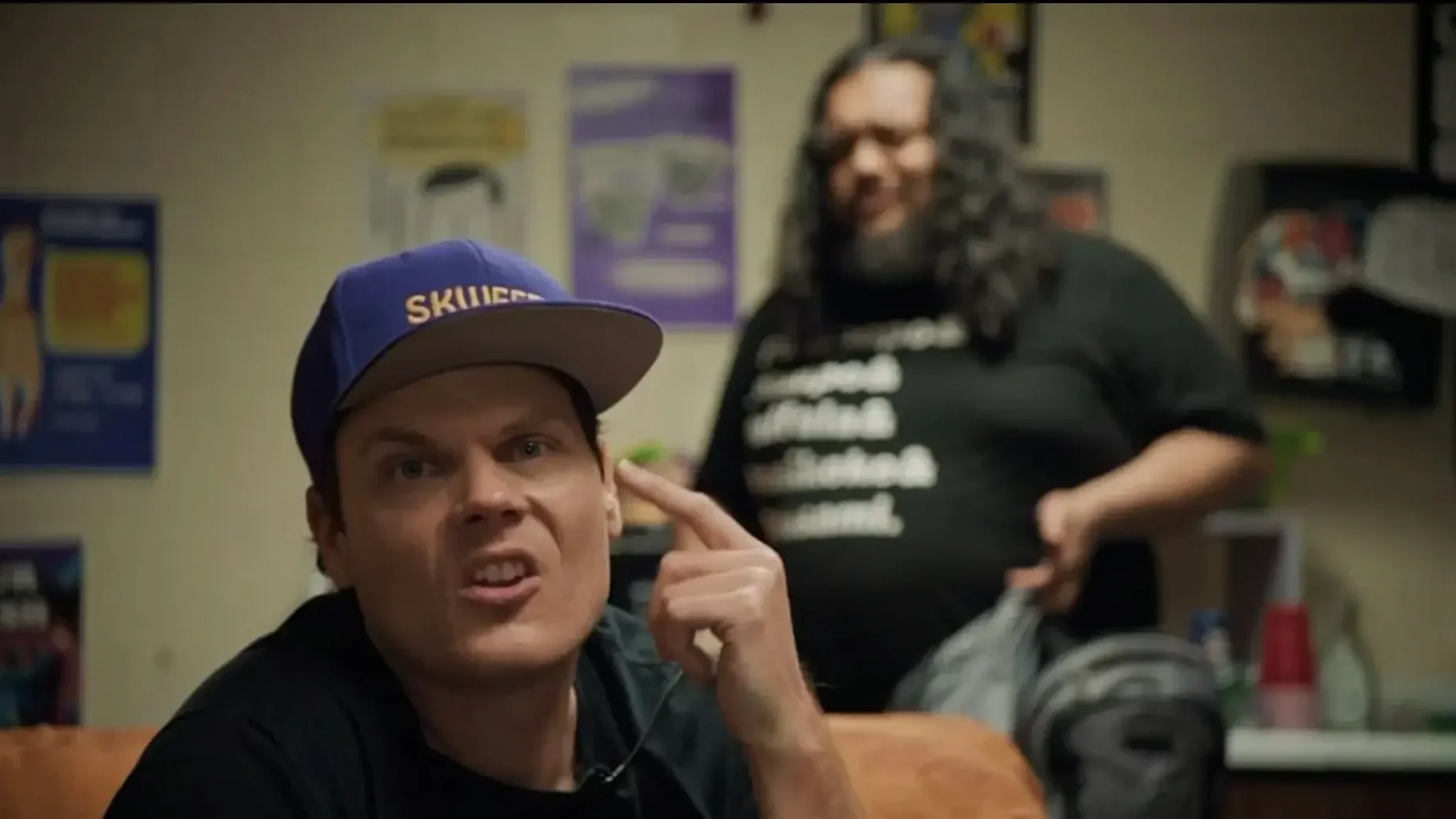 Skweezy Jibbs (Tim Savage) looks to the camera with his friend Adam Pasi in the foreground.