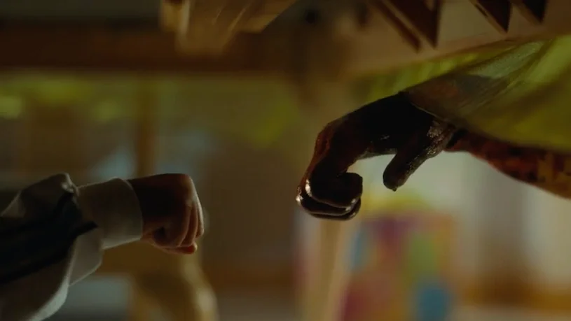 Jupe's fist lifts to bump with Gordy the chimp's bloodied fist under the table.