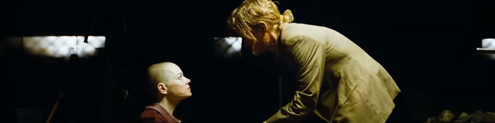 Emma Stone stares up at Jesse Plemons in Bugonia.