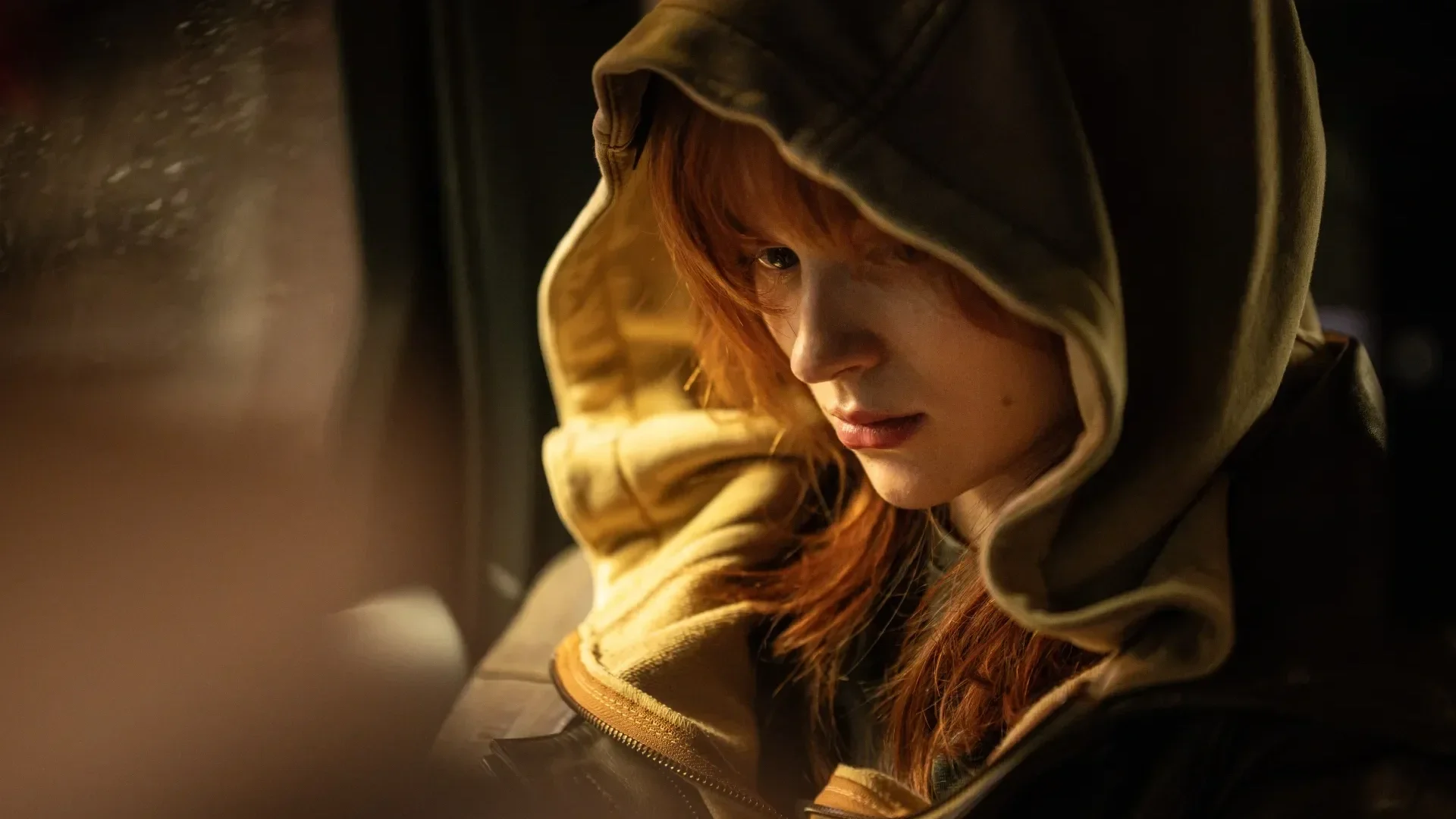 Jean Grey (played by Sadie Sink) looks to the side while wearing a huge hoodie in the film 'Spider-Man: A Brand New Day.'