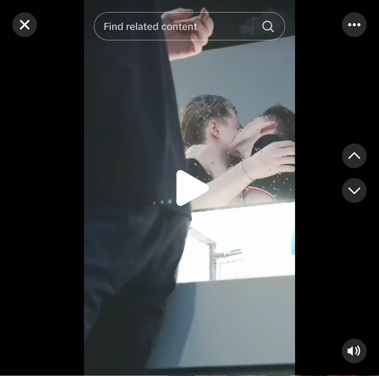 A screenshot of a tiktok. A bathroom mirror reflecting two white boys making out.