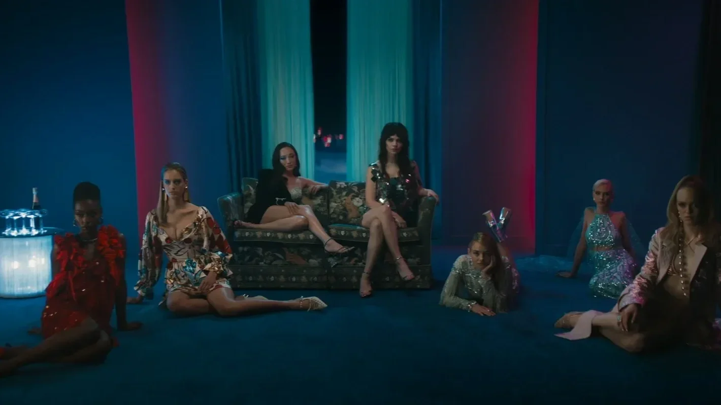 Dominique (played by Havana Rose Liu), Elle (Sophie Thatcher), and Hunter (played by Kristine Froseth) lay in glitzy outfits among the other models in the film Her Private Hell.