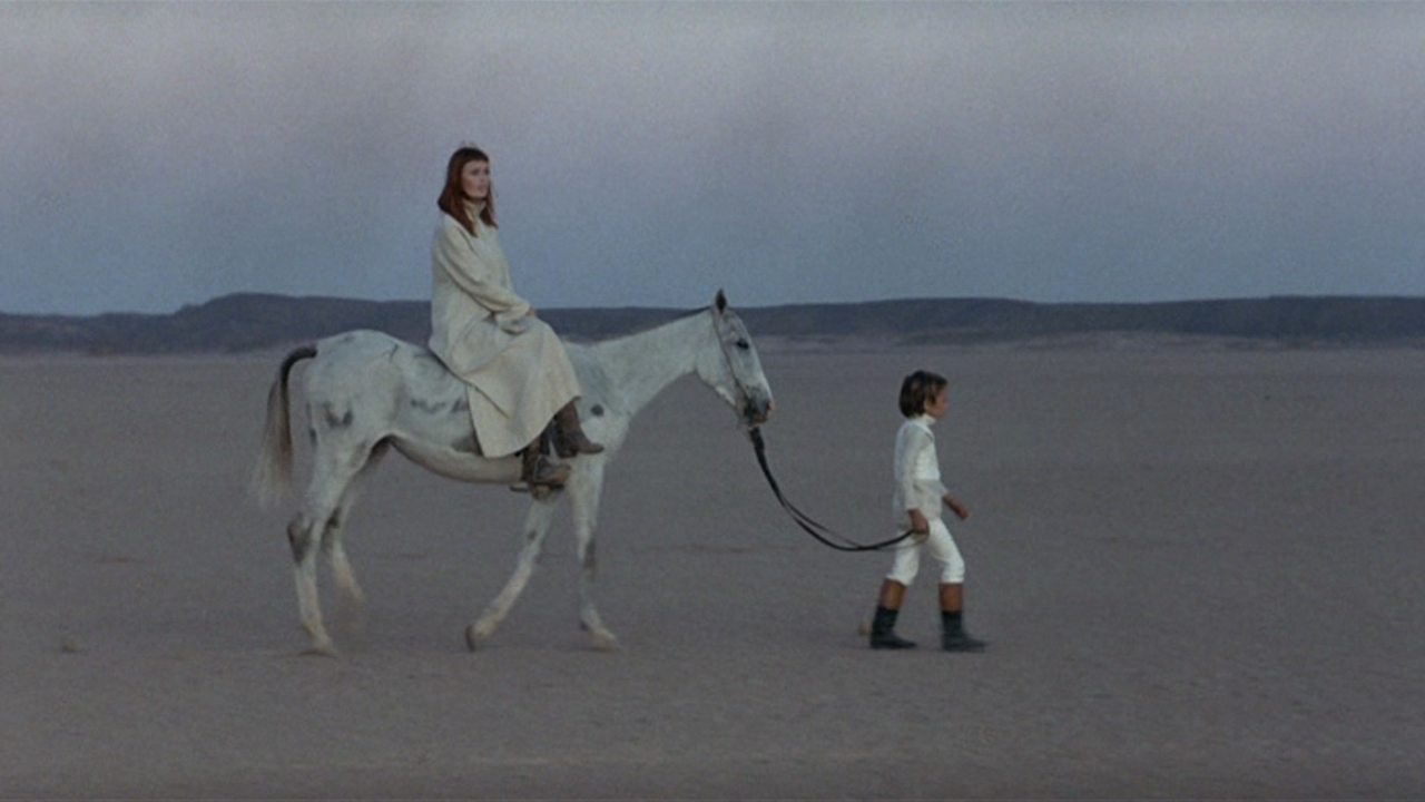 Nico sits on top of a horse in a desert with a child holding the reigns in the 1972 film, The Inner Scar.