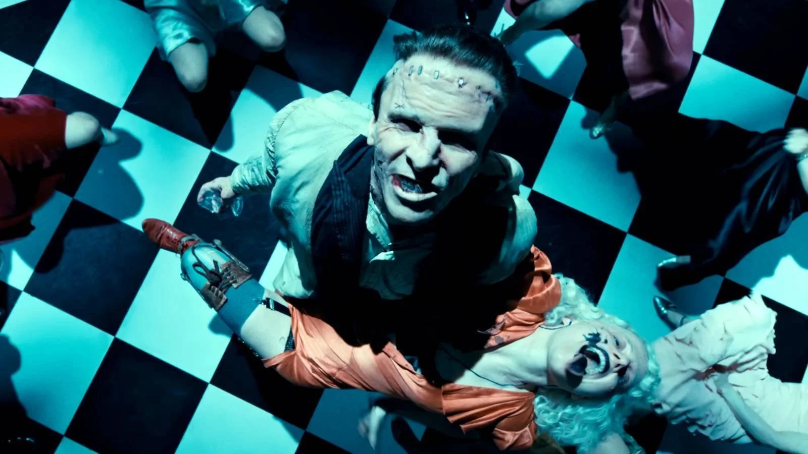 Christian Bale as Frankenstein's Monster spins Jessie Buckley as The Bride on a crowded dance floor.