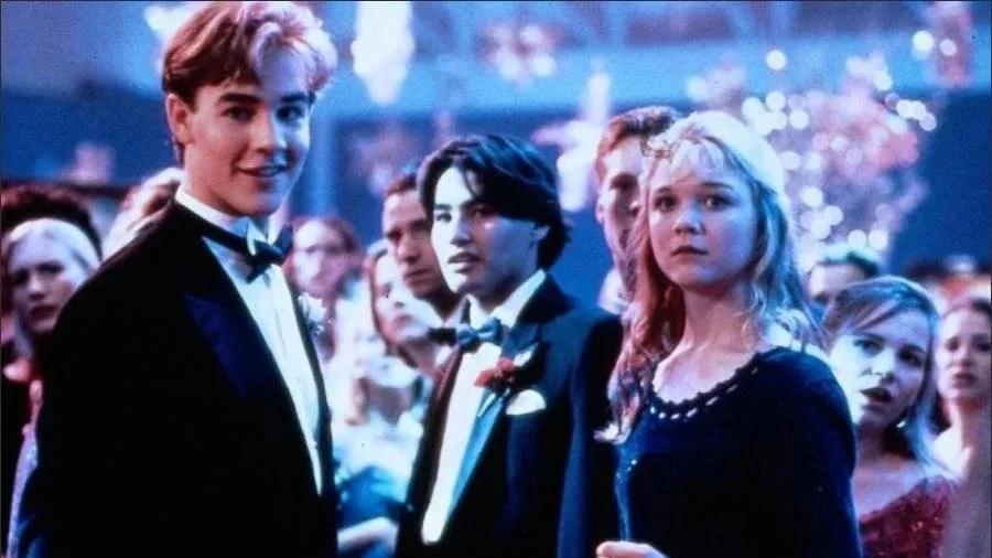 Rick Sandford (played by James Van Der Beek) smirks menacingly beside Melissa (played by Ariana Richards) at the Winter Ball in the 1995 film, 'Angus.'