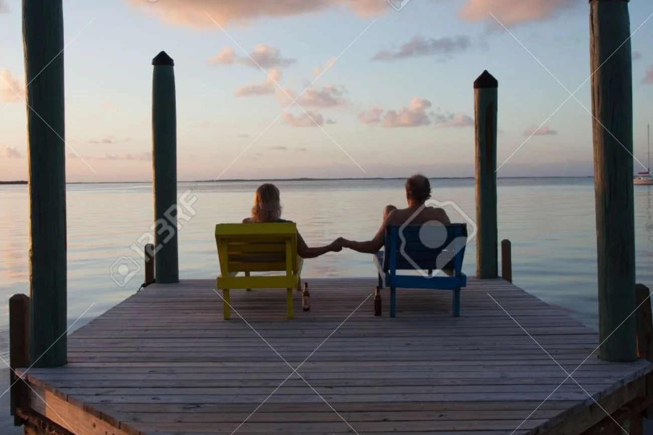 17380003-Couple-sits-on-dock-and-dreams-of-the-future-while-watching-a-beautiful-sunset-Stock-Photo.jpg