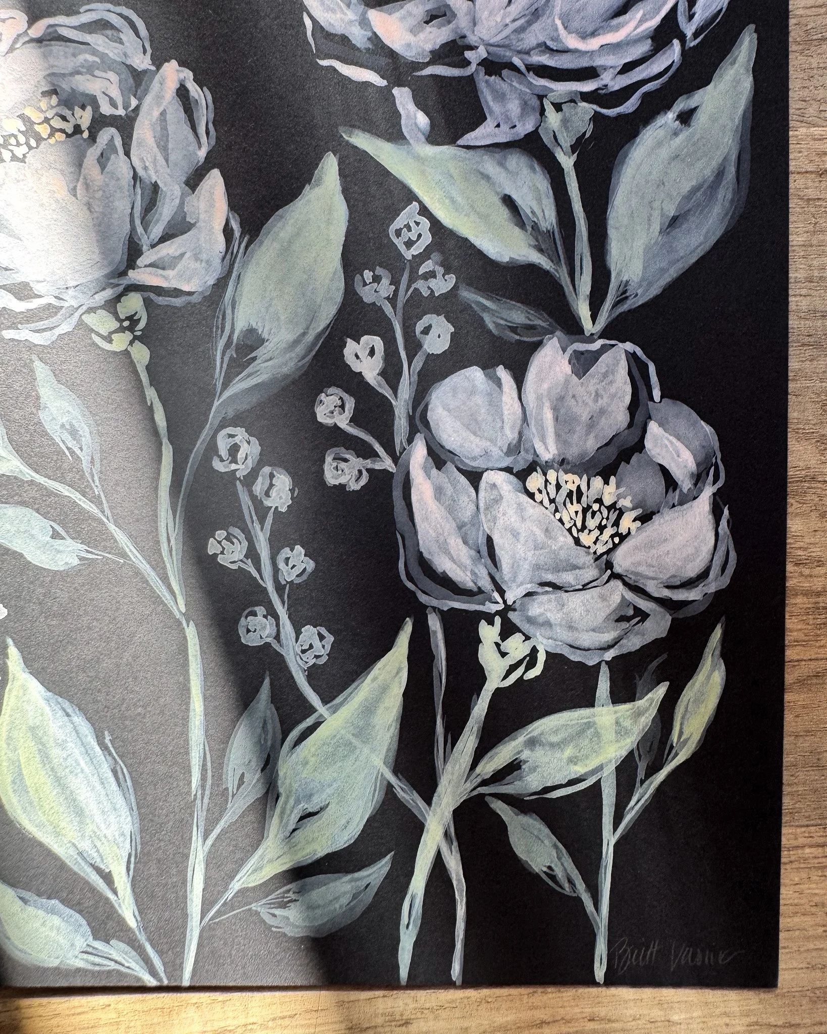 Close-up of white acrylic petals and signature on black paper