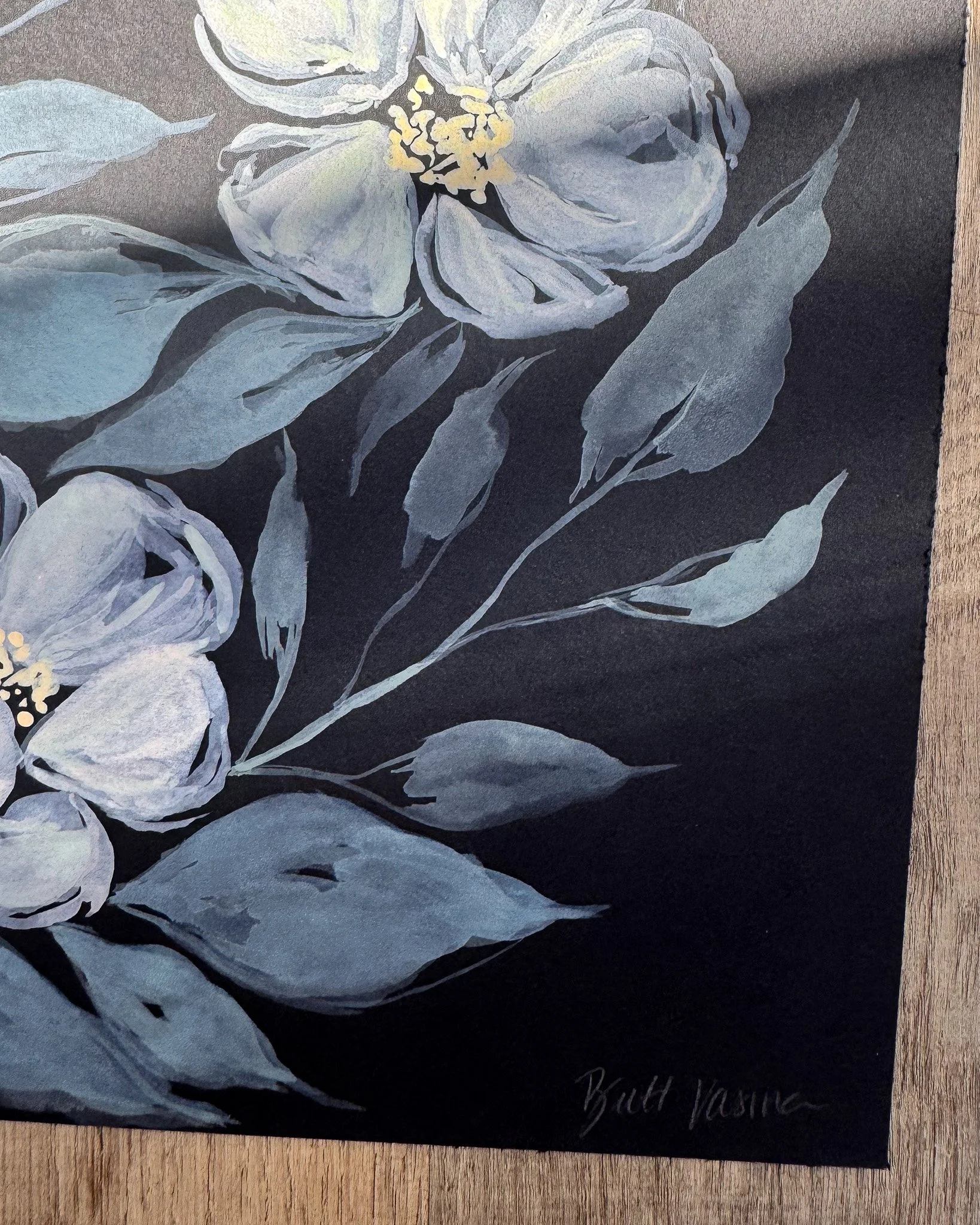 Close-up of white acrylic petals and signature on black paper