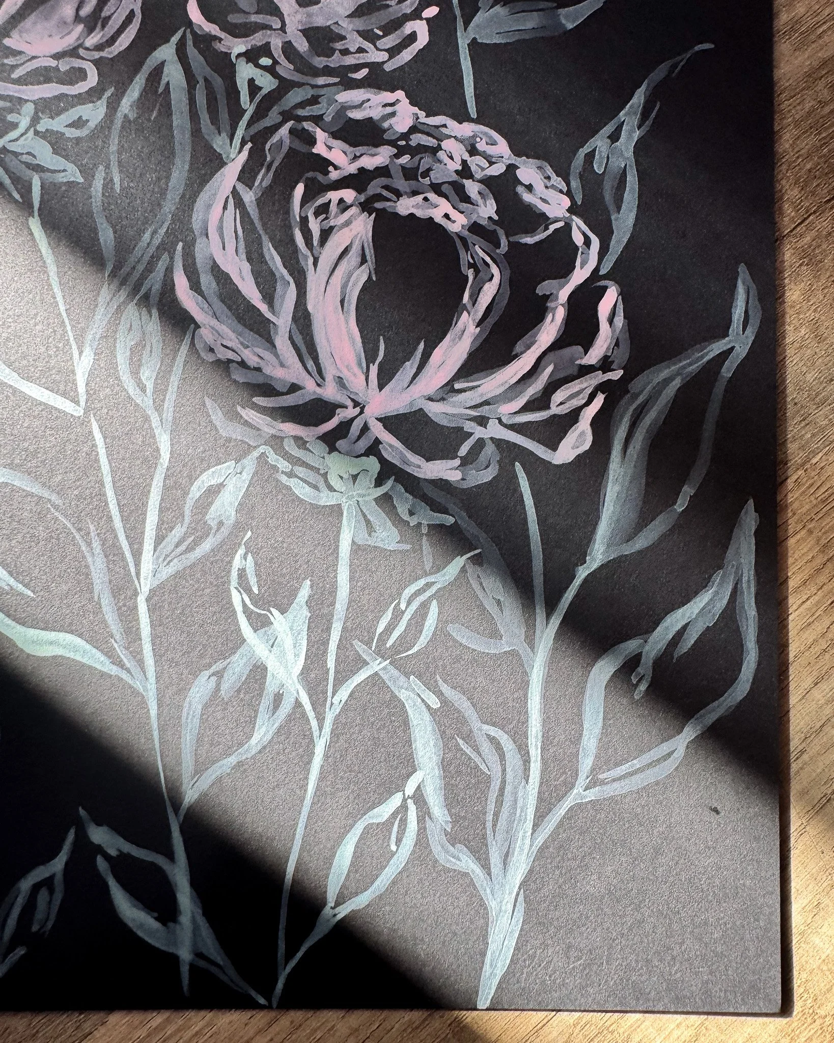 Close-up of white acrylic petals and signature on black paper