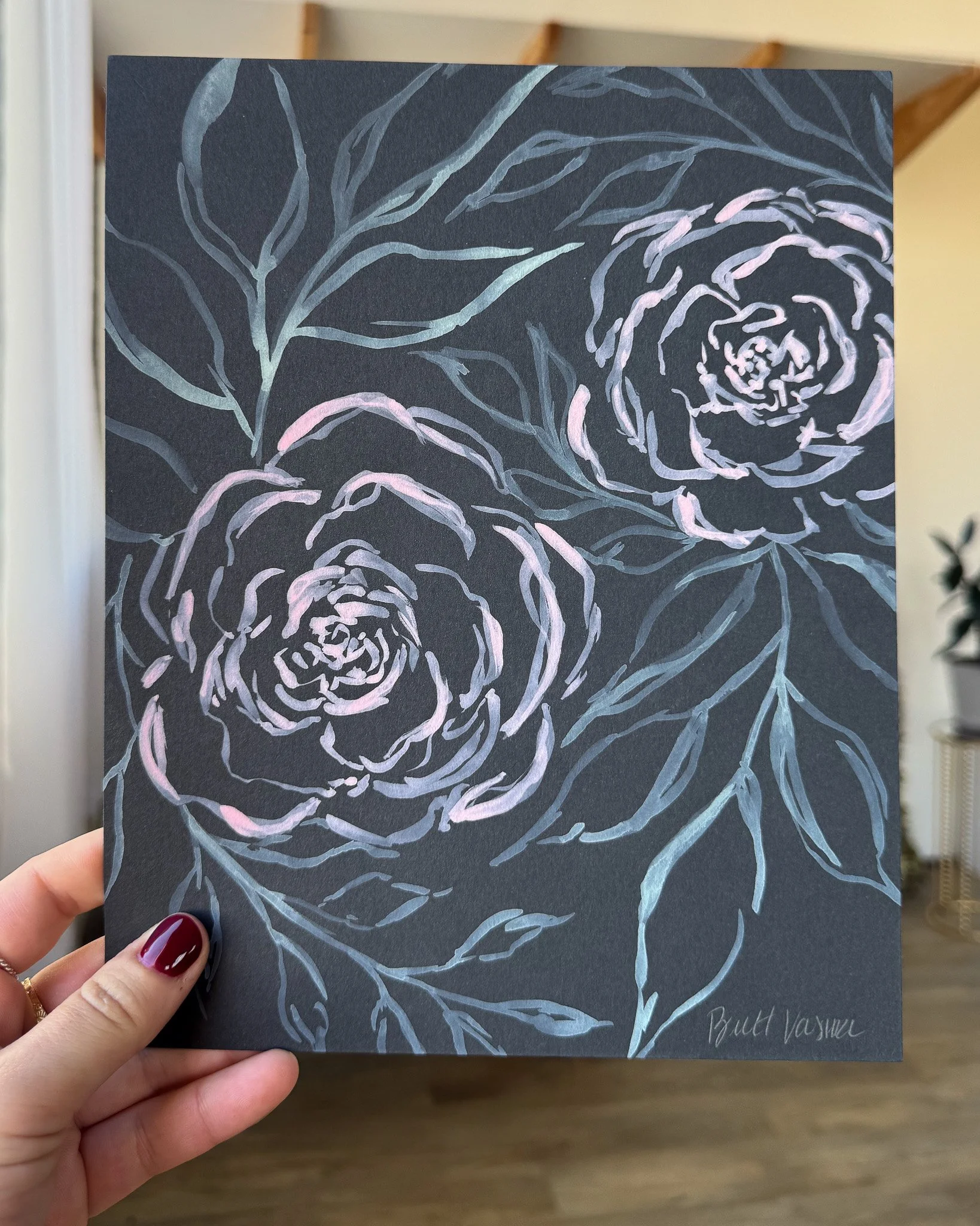 Hand holding an original acrylic floral painting on black paper