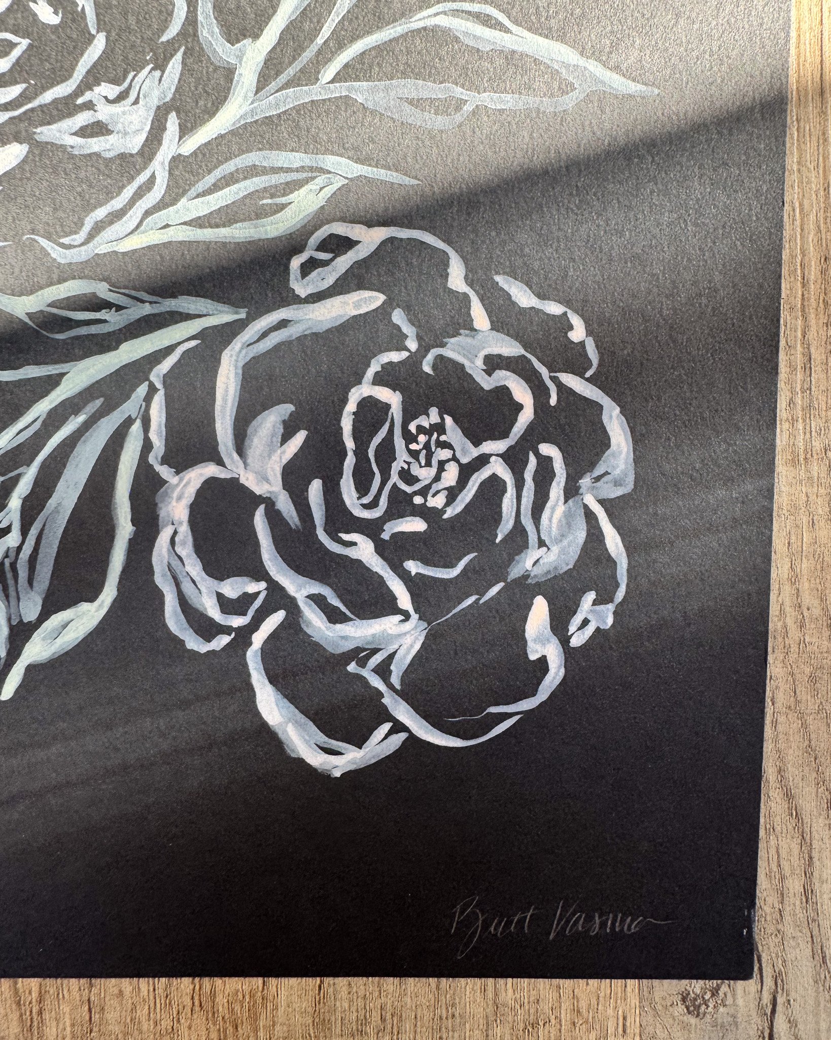 Close-up of white acrylic petals and signature on black paper