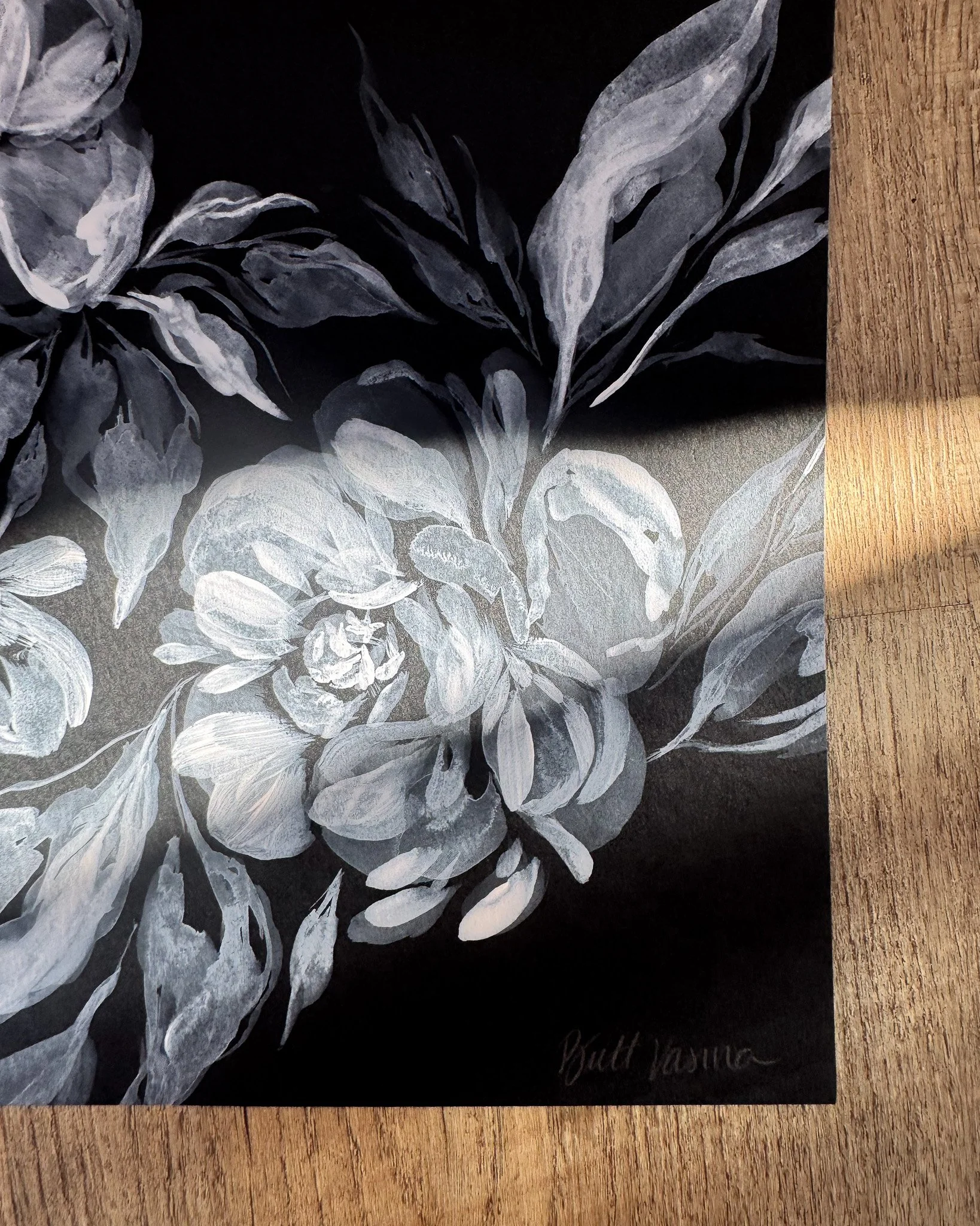 Close-up of white acrylic petals and signature on black paper