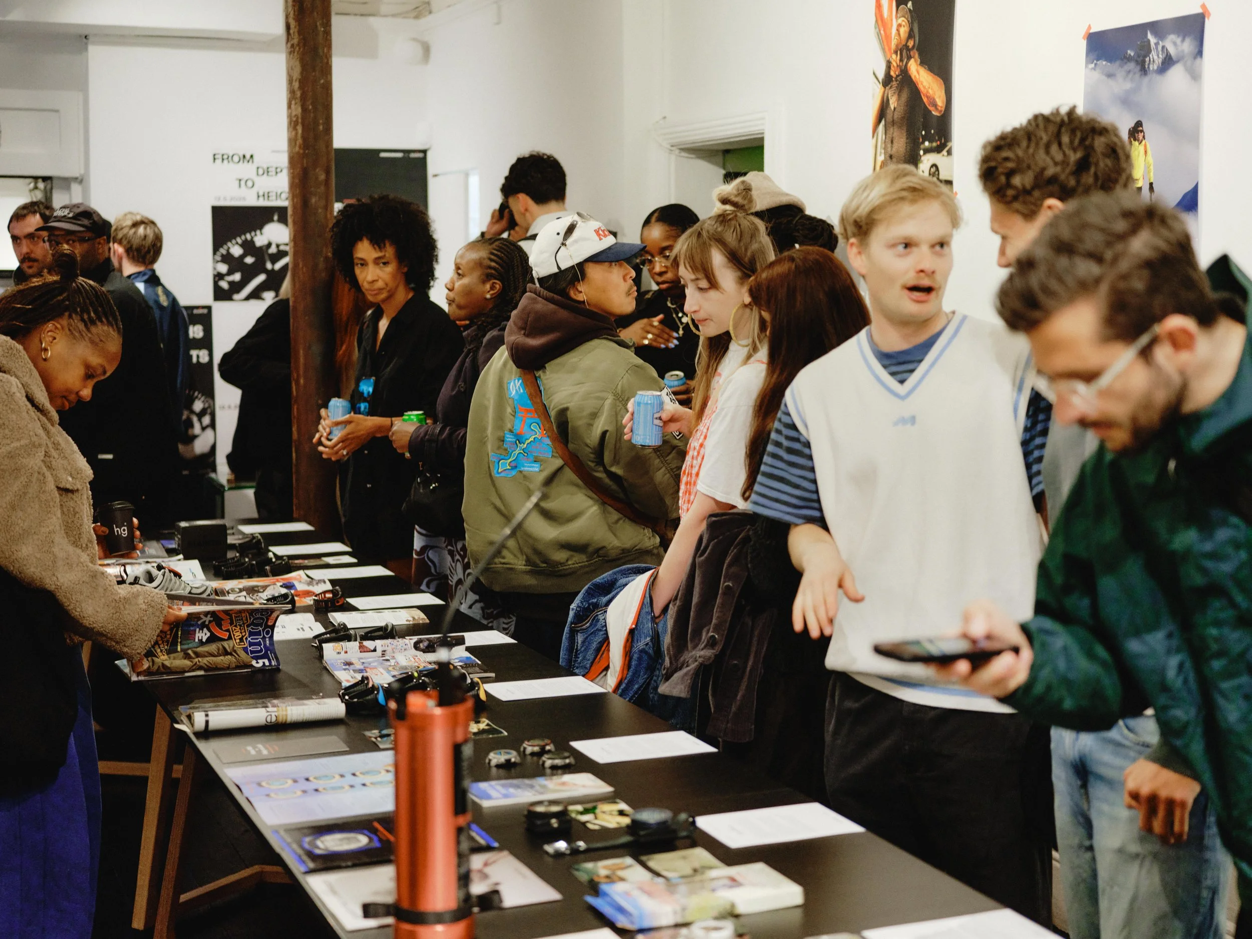  Guests gather around Suunto archive pieces during the brand’s 90-year anniversary exhibition. 