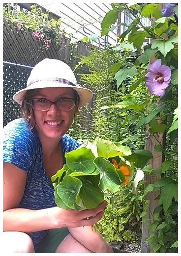 Super-volunteer Kelsey Patton with her zesty edible nasturtium bouquet and tropical rose-of-sharon for backdrop ( Sage Rising , Toronto, ON).