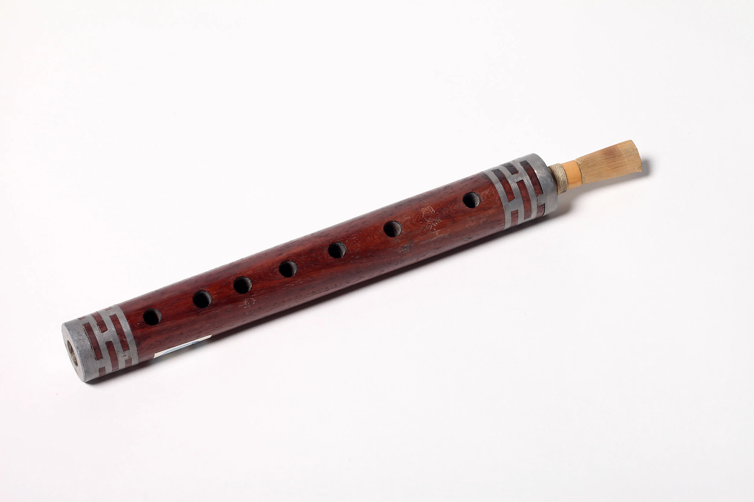 Guan (double-reed pipe) is the name of a musical instrument, known as “ bili ” in ancient time. It is a wind instrument that originated from Guizi (today’s Kucha, Xinjiang). In Sui and Tang dynasties, it was used in Jiubuyue (nine kinds of music) and Shibuyue (ten kinds of music); in Song dynasty, there was a bili bu ( bili department) in the jiaofang shisan bu (thirteen departments of court conservatory). According to Xu Wei’s Nanci xulu (a Ming history of drama), “now southern songs are sung to the accompaniment of dizi , guan , sheng and pipa ”, which suggests that guan is among the traditional kunqu accompanying instruments. As described in Jichangyuan wenge ji ( A Record of Hearing Singing in Garden of Ecstasy ), “ xiao and guan are essential for making chords…Xie Linquan was good at playing guan as an accompaniment instrument…” As some veteran artists recall, in the past, northern songs were sung to the accompaniment of guanzi , which was later replaced by suona . Guanzi is a wind instrument consisting of a wood cylindrical tube with eight holes on it (seven finger holes on the top and one thumb hole on the back) and a reed made from Arundo cane that is inserted into the top end of the tube. Guanzi is available in three sizes: the large, medium and small sizes with the full range of over two octaves. Its upper range sounds sharp and penetrating, the mid range smooth and loud and lower range deep and sustaining with a bit nasal voice. Guanzi is also blown for folk occasions and religious rituals.