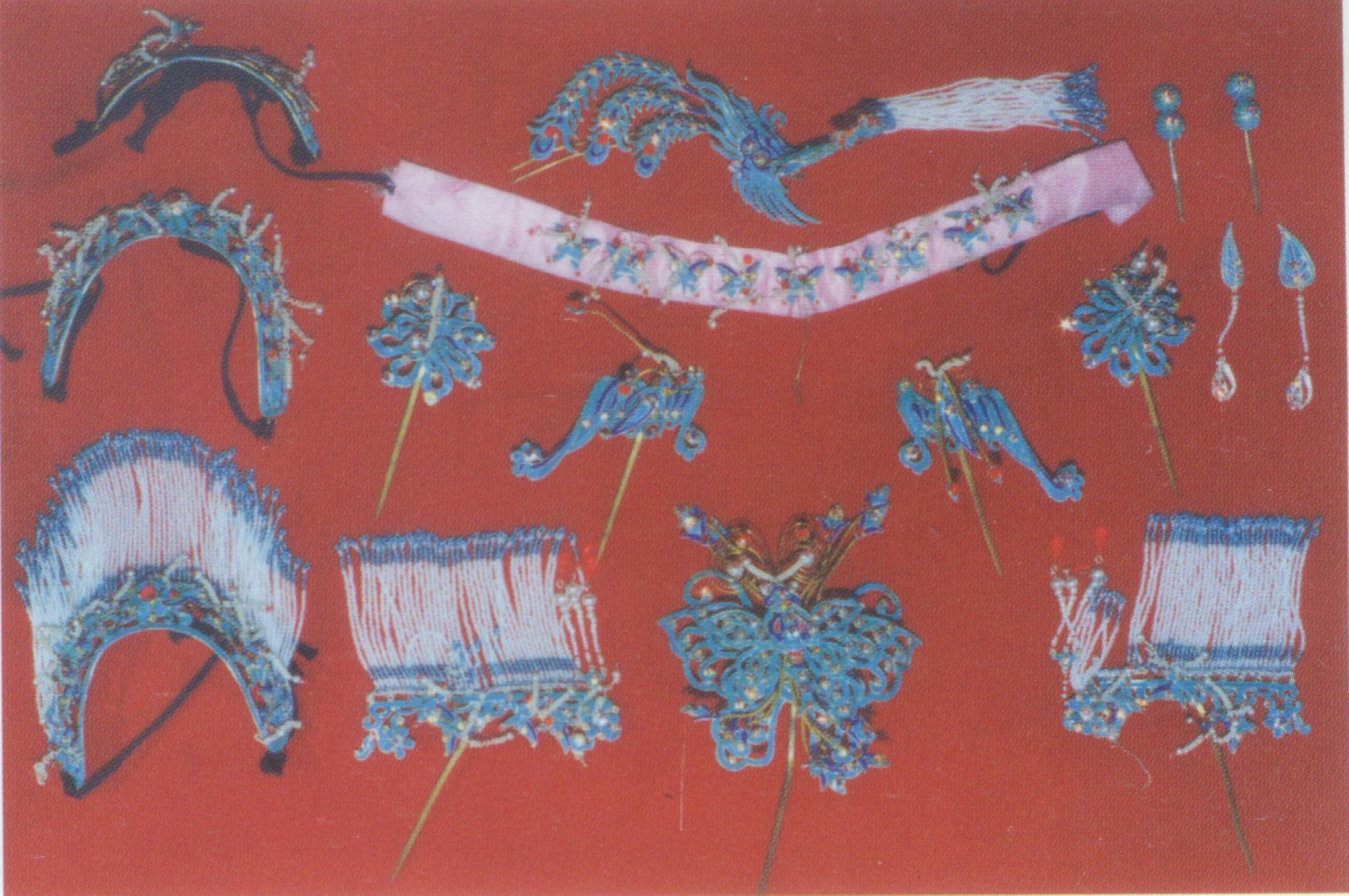 Diancui toumian headdress for Dan role. It is made by inlaying the feather of kingfishers in a metal base. The feather comes in colors including cerulean blue, mint green, and navy blue. Other accessories are paozi(beads)、earings, main pins, bat-shaped and phoenix- shapedaccessories and dinghua( main accessory in the middle). Diancui is often worn by refined and decorous ladies.