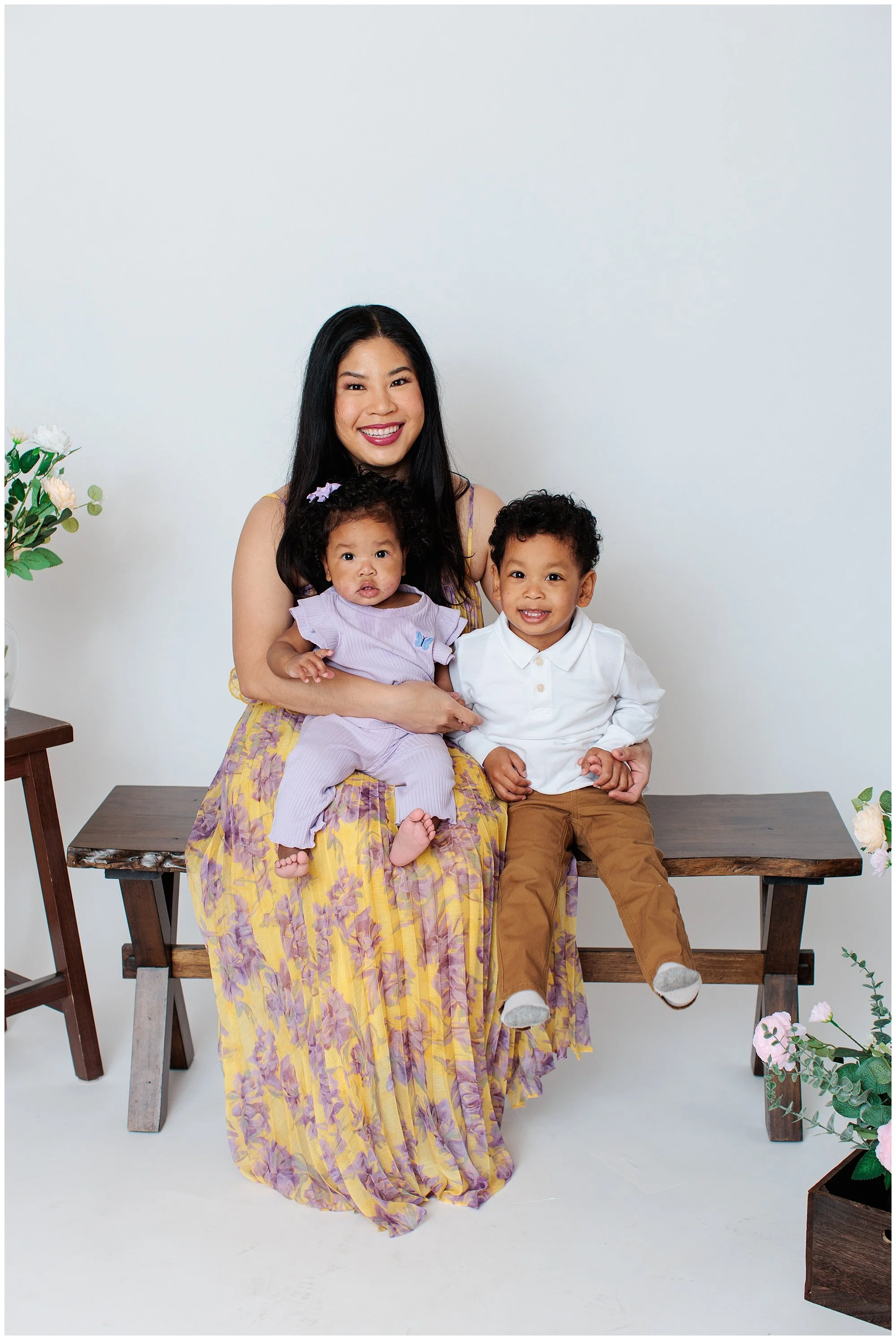 young mom with 2 kids on her lap in white silver spring studio