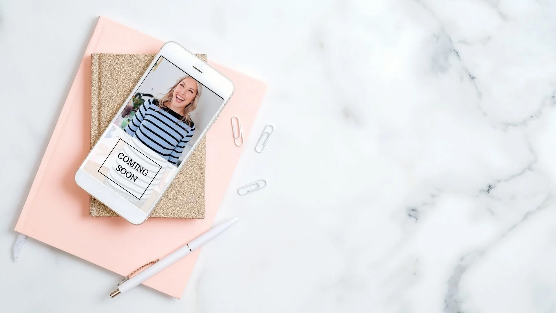 branding photo of smartphone on desk with book and pen
