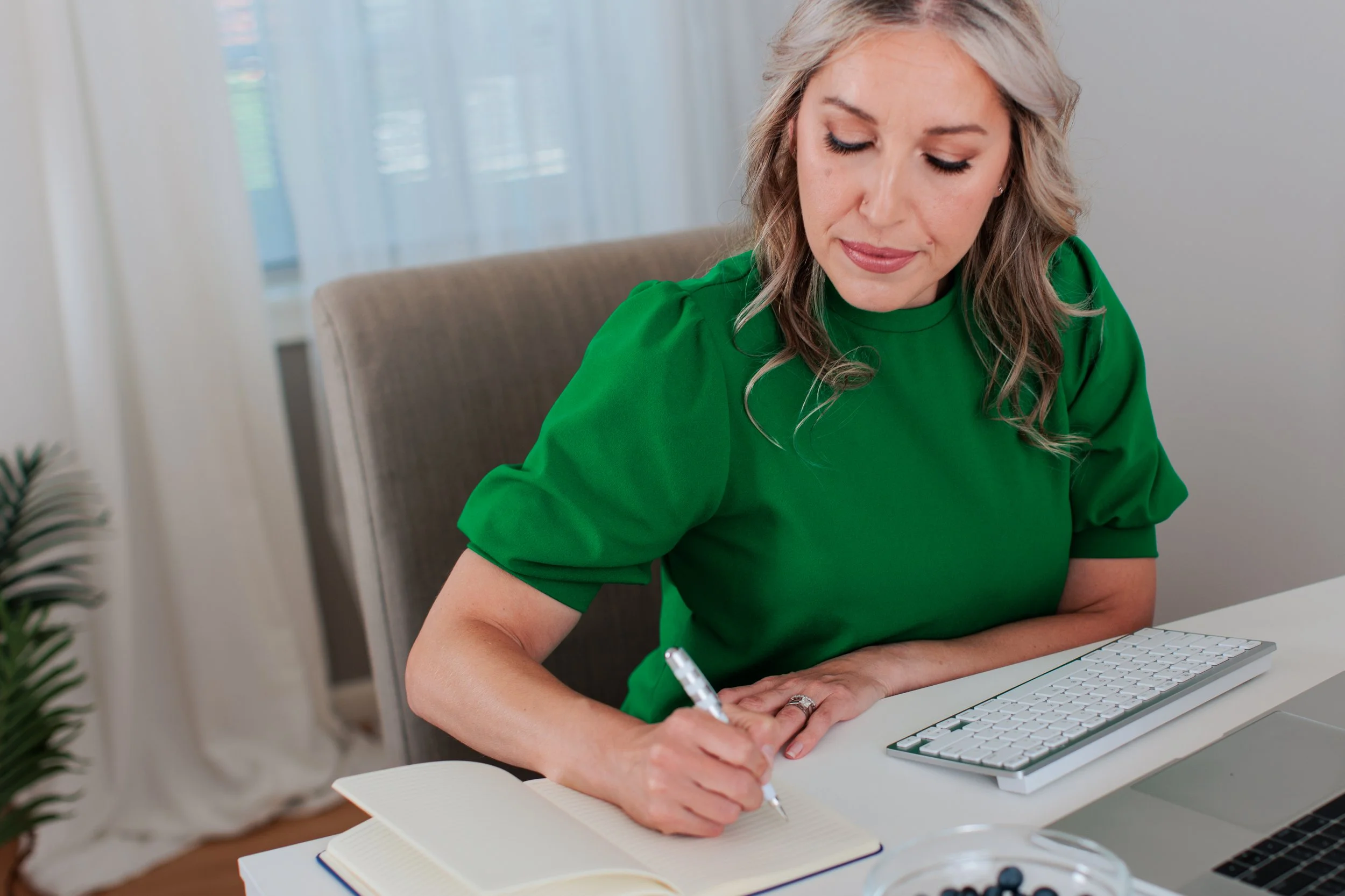 brand image of blonde female working at desk in green shirt