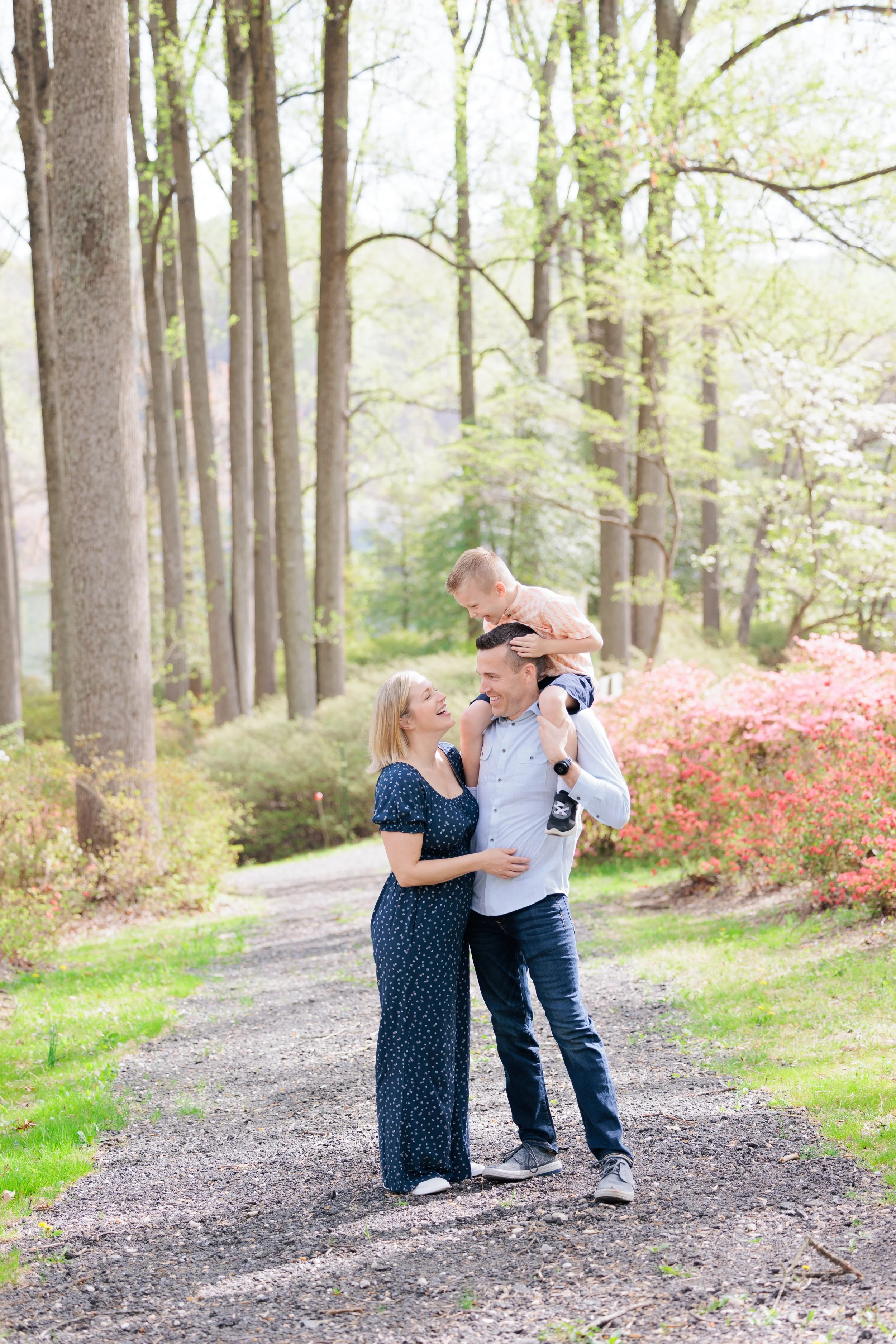 Family walking along a wooded trail during a relaxed spring photo session in Montgomery County, Maryland