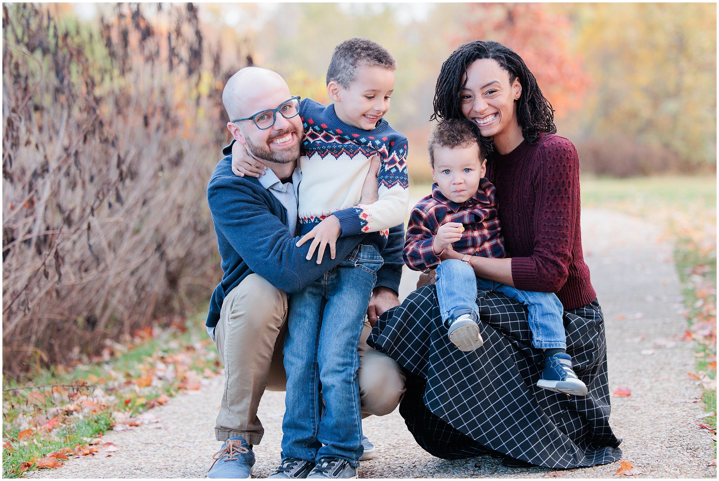 interracial family hugging and smiling together during fall family photo session