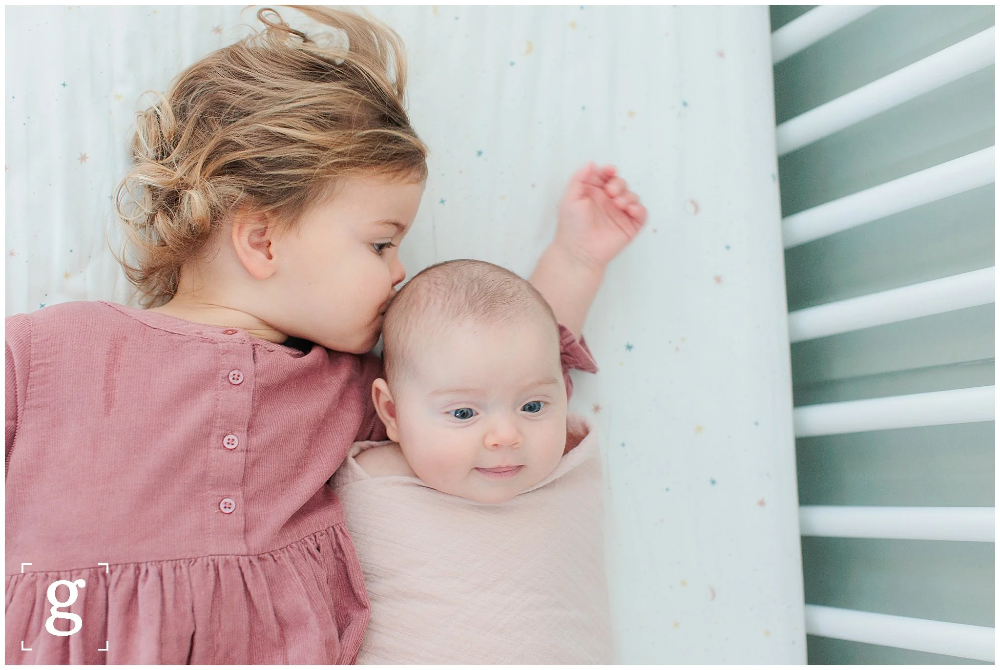 baby and sister in crib during lifestyle newborn session in washington dc