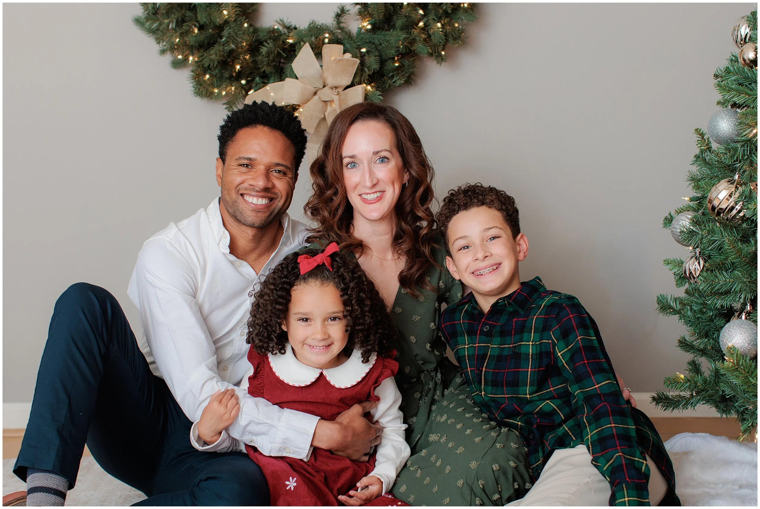 Family smiling together during Christmas mini session in Silver Spring studio