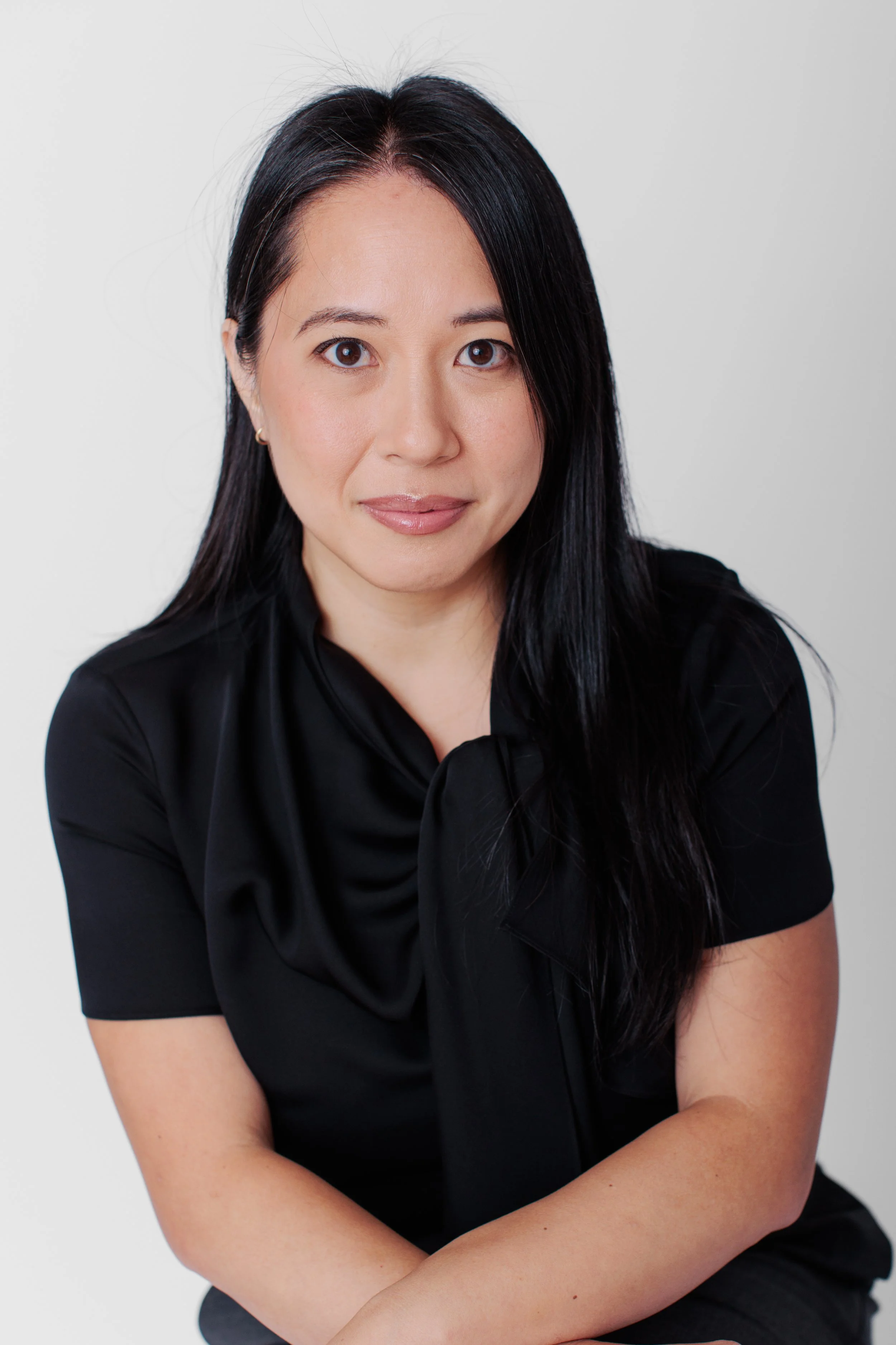 Clean studio headshot of a professional woman wearing a black blouse in Silver Spring Maryland. 