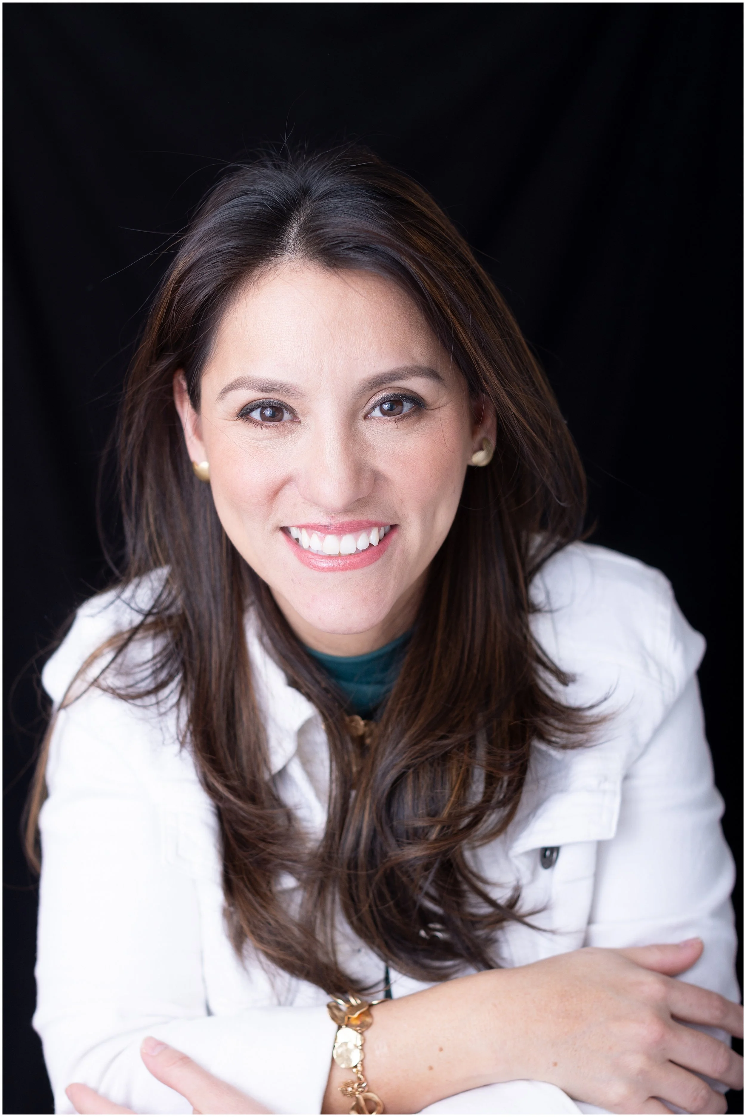  Studio headshot of a woman wearing a white jacket against a dark backdrop in Silver Spring MD. 