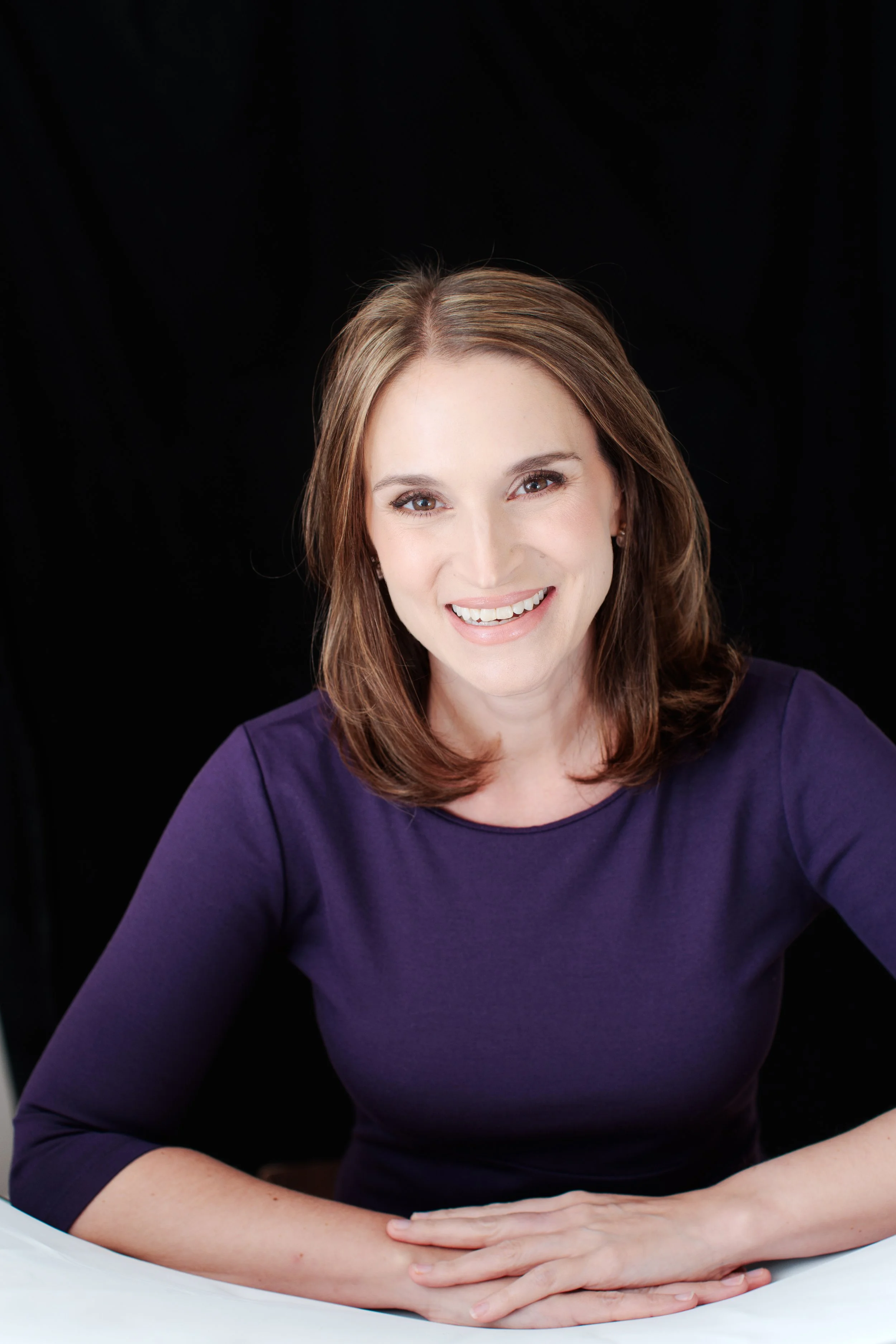  Professional headshot of a female lawyer in a purple top photographed indoors in Silver Spring MD. 