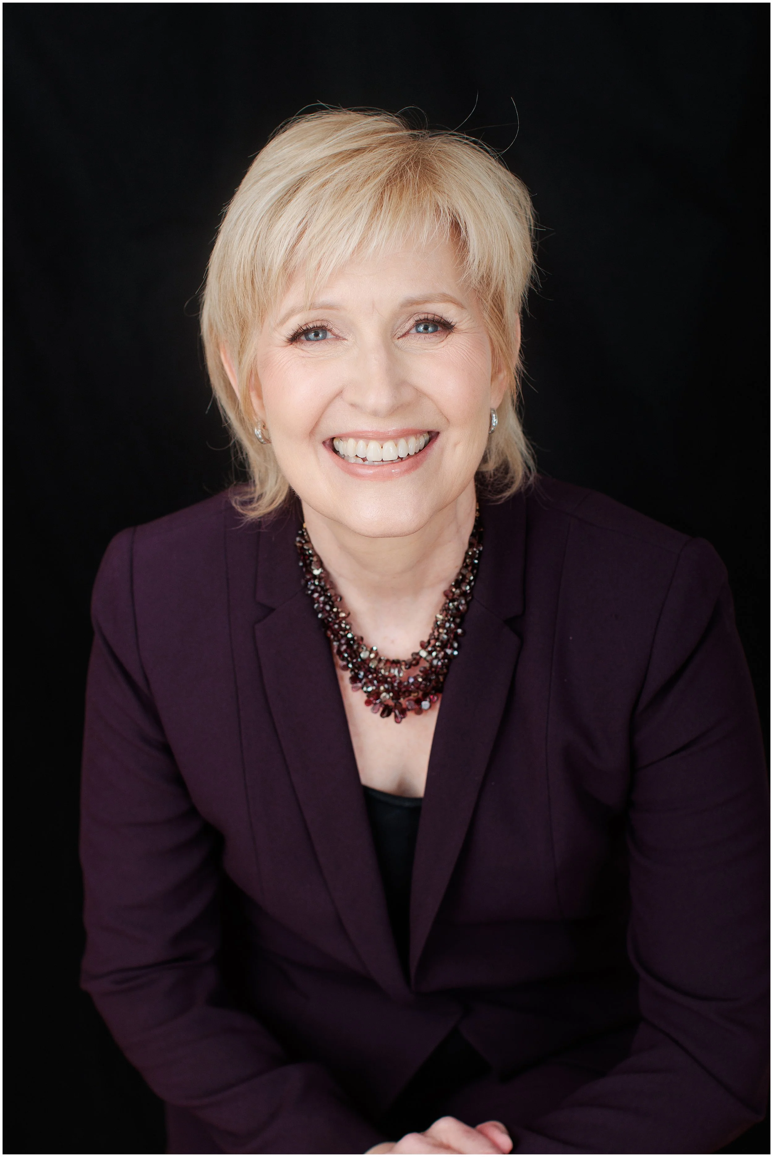  Professional headshot of a woman in a plum blazer photographed in my Silver Spring MD studio. 