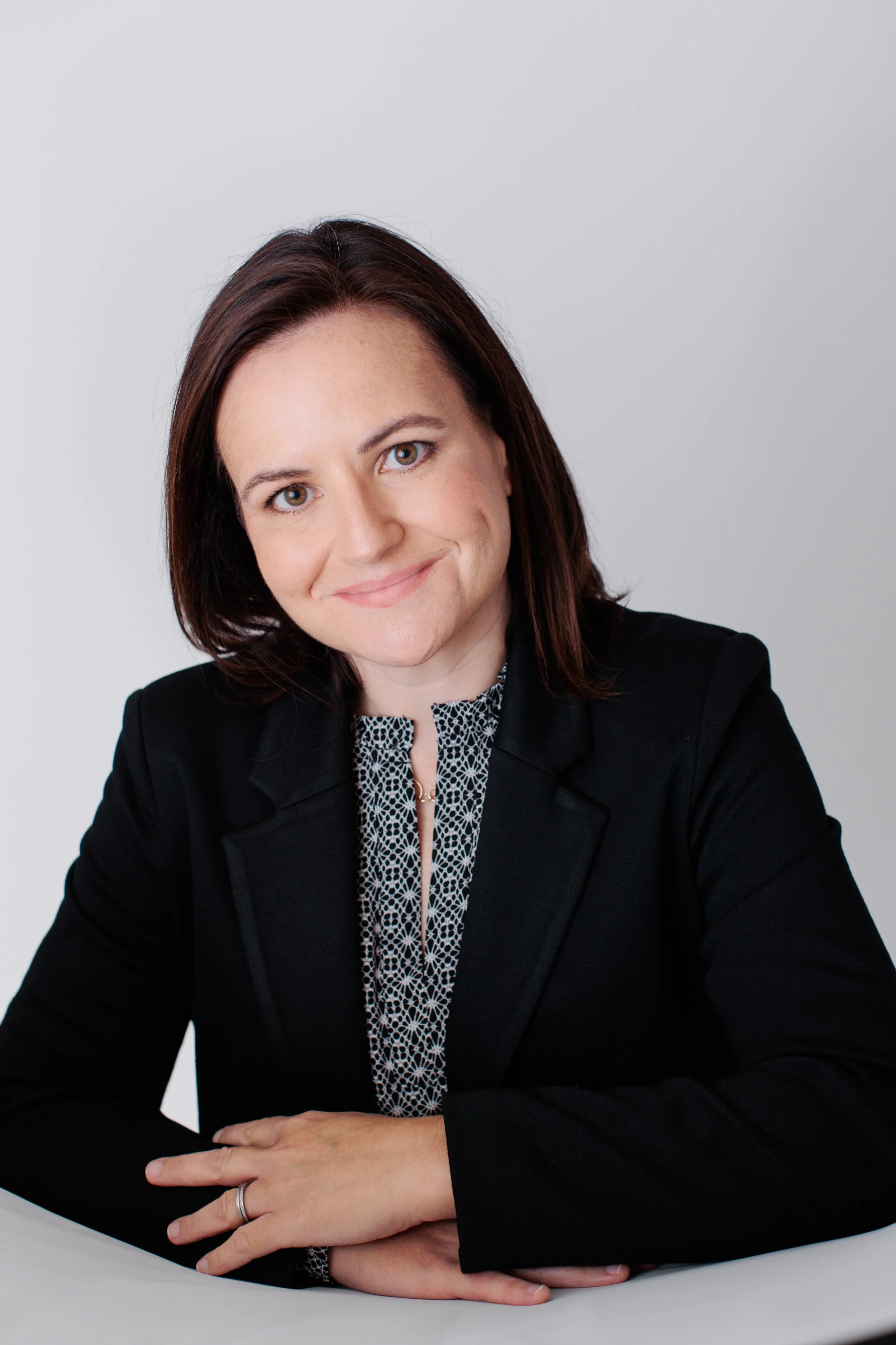  Professional headshot of a woman in a black blazer photographed in natural light in my Silver Spring MD studio. 