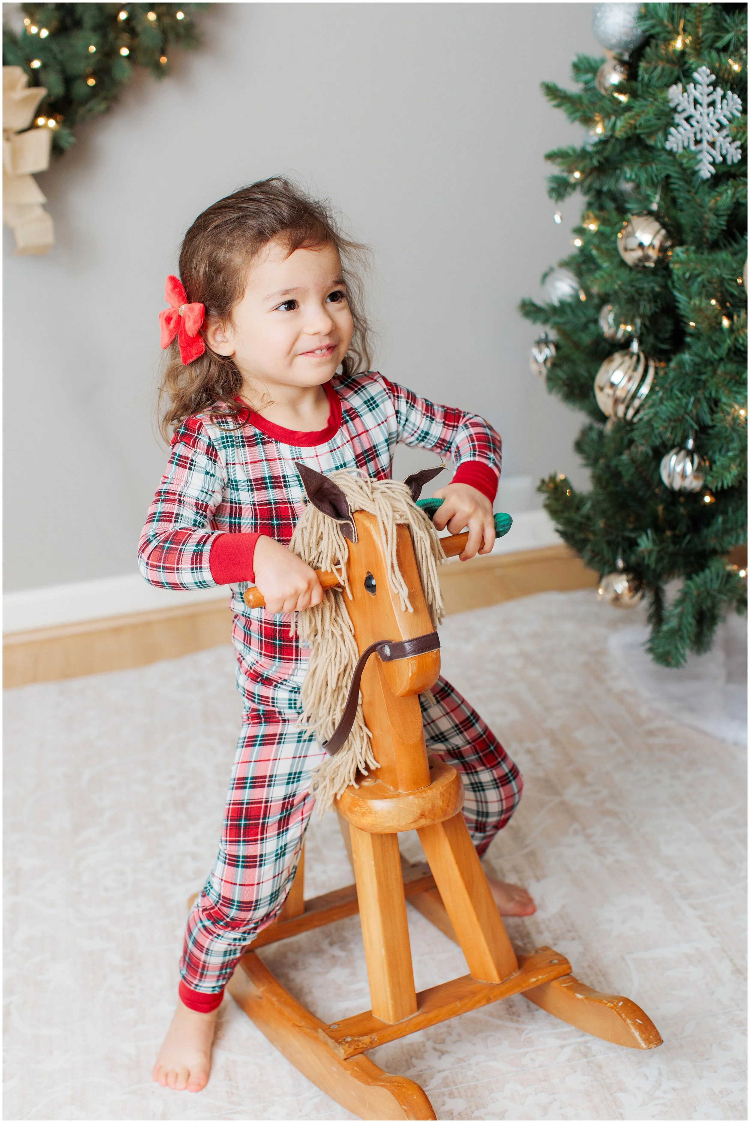Little girl in Christmas PJ's on a rocking horse
