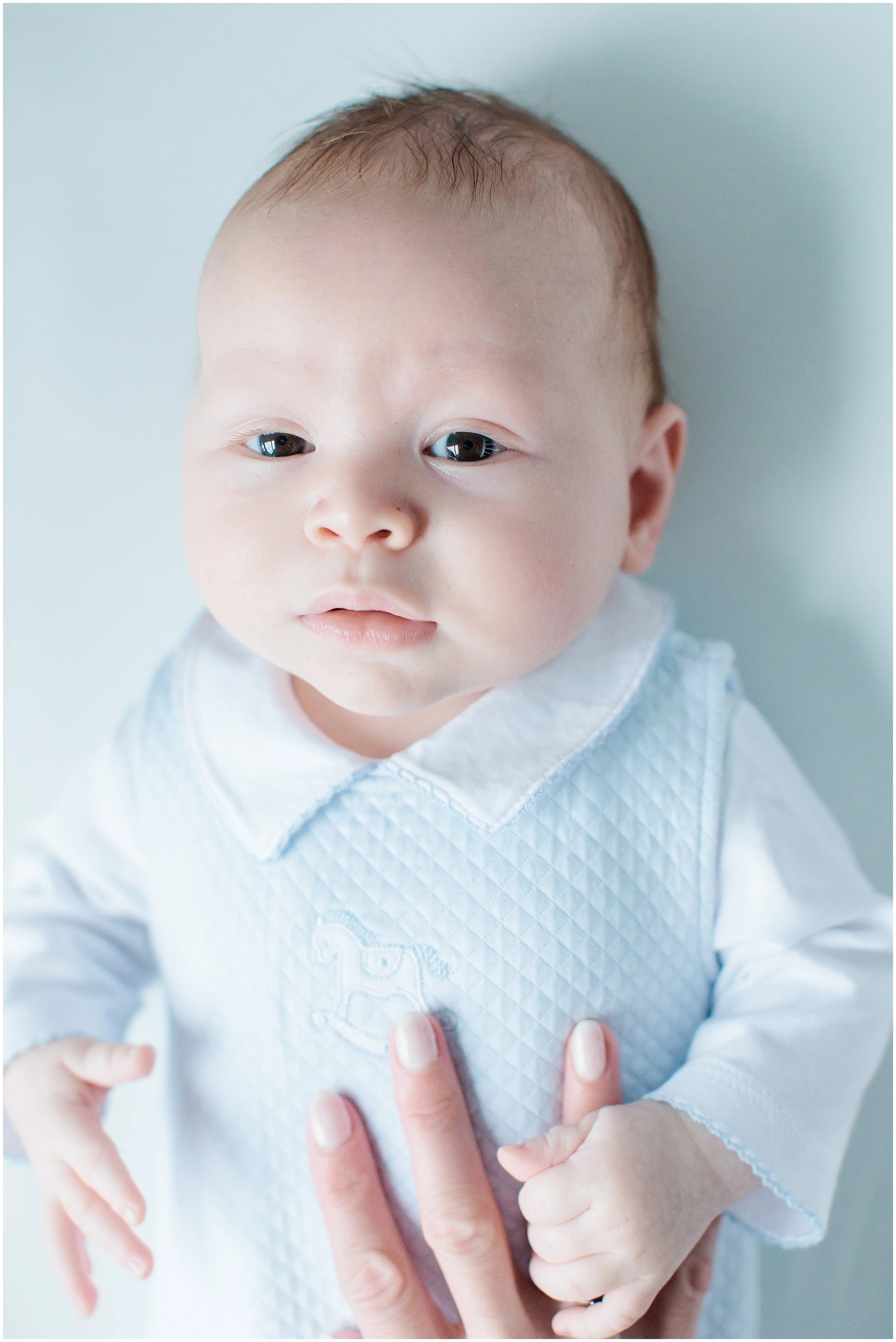 baby boy laying in crib wearing blue