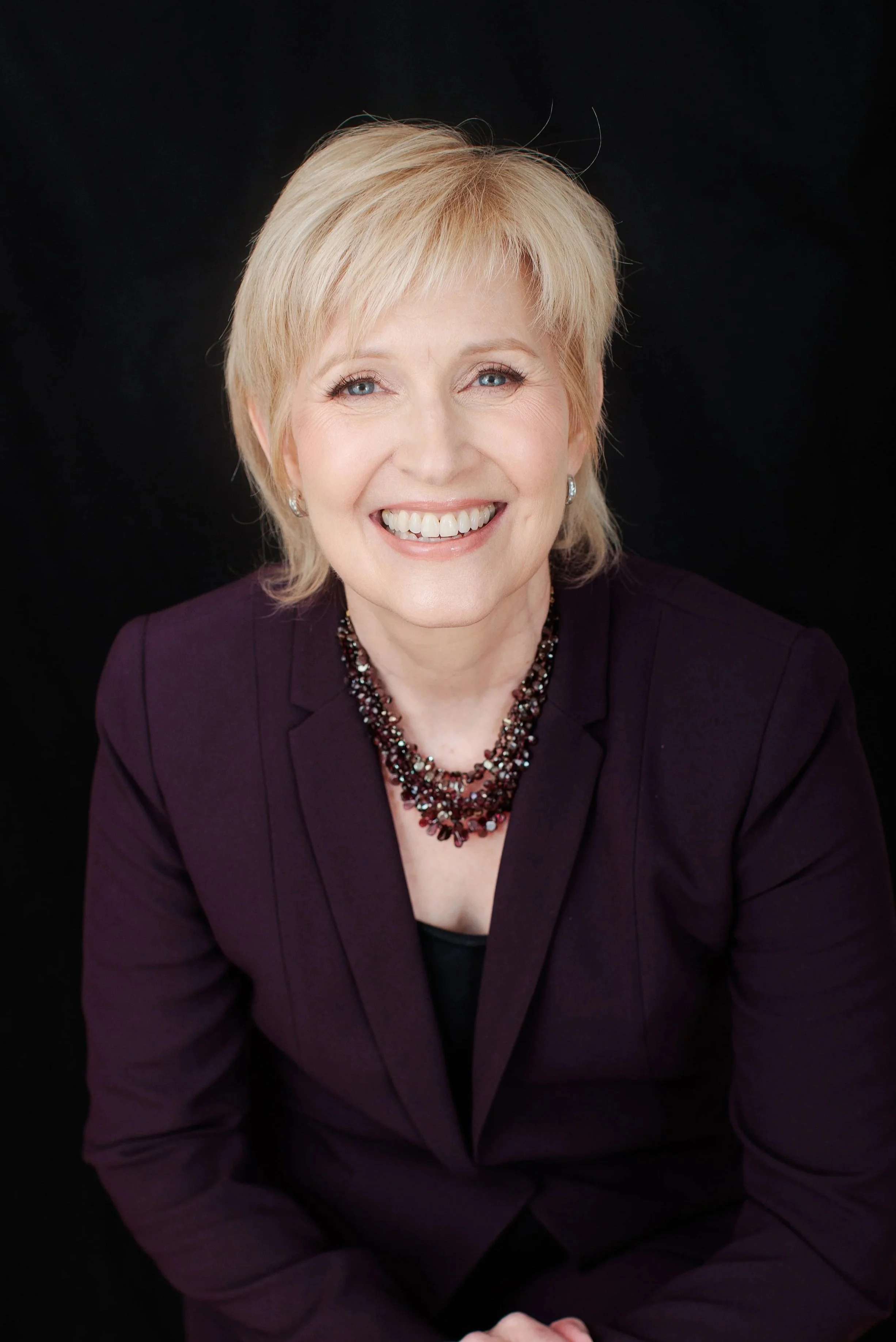  Professional headshot of a woman in a plum blazer photographed in my Silver Spring MD studio. 