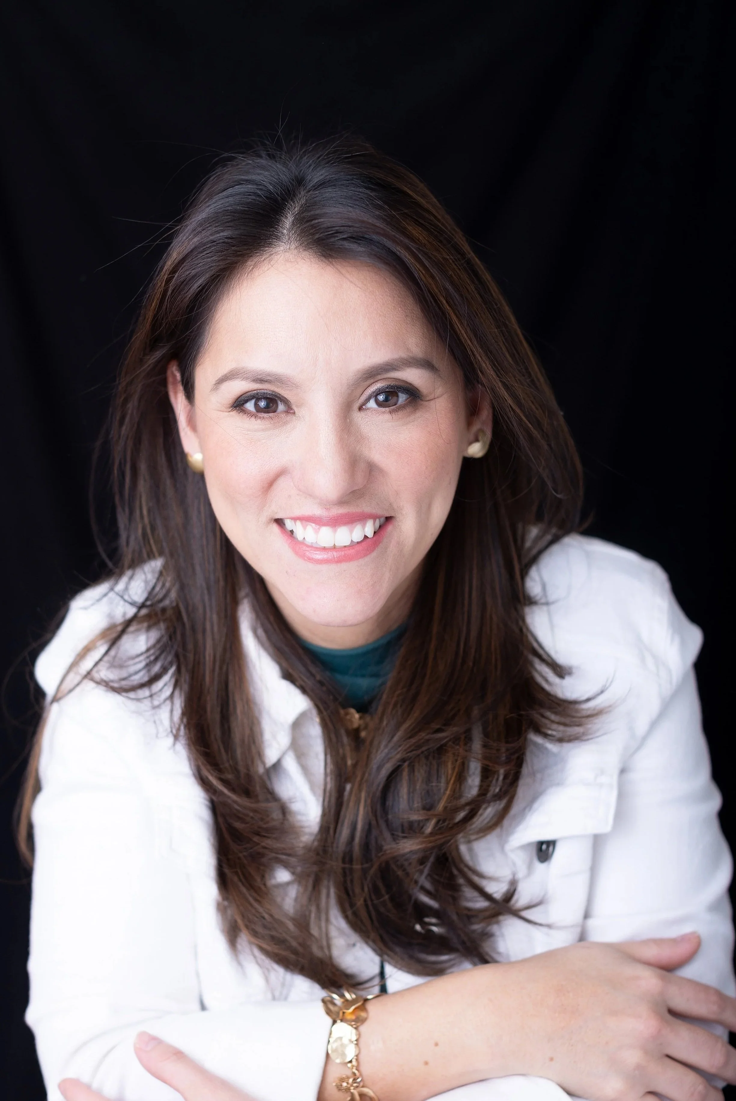  Studio headshot of a woman wearing a white jacket against a dark backdrop in Silver Spring MD. 