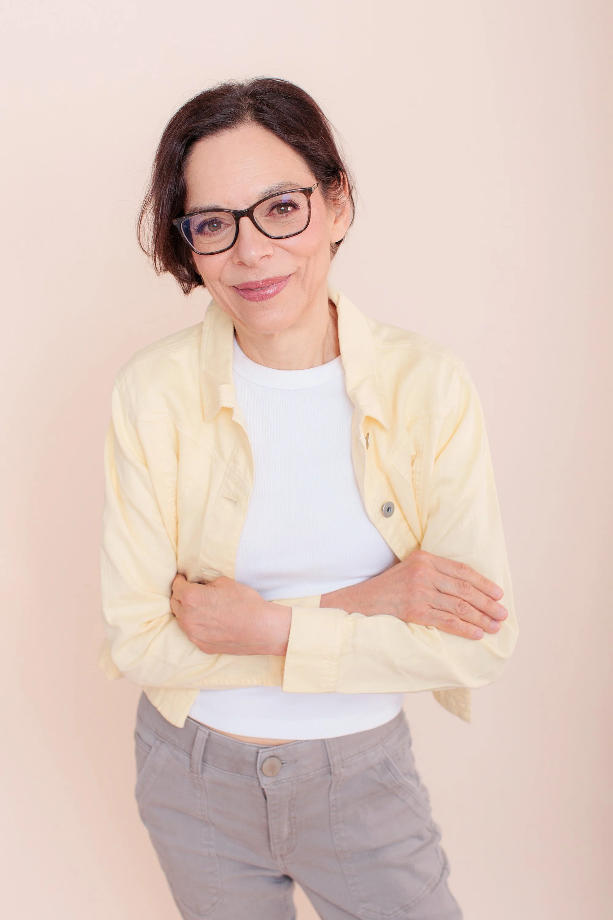  older professional woman in yellow jacket with crossed arms for linkedin photo 