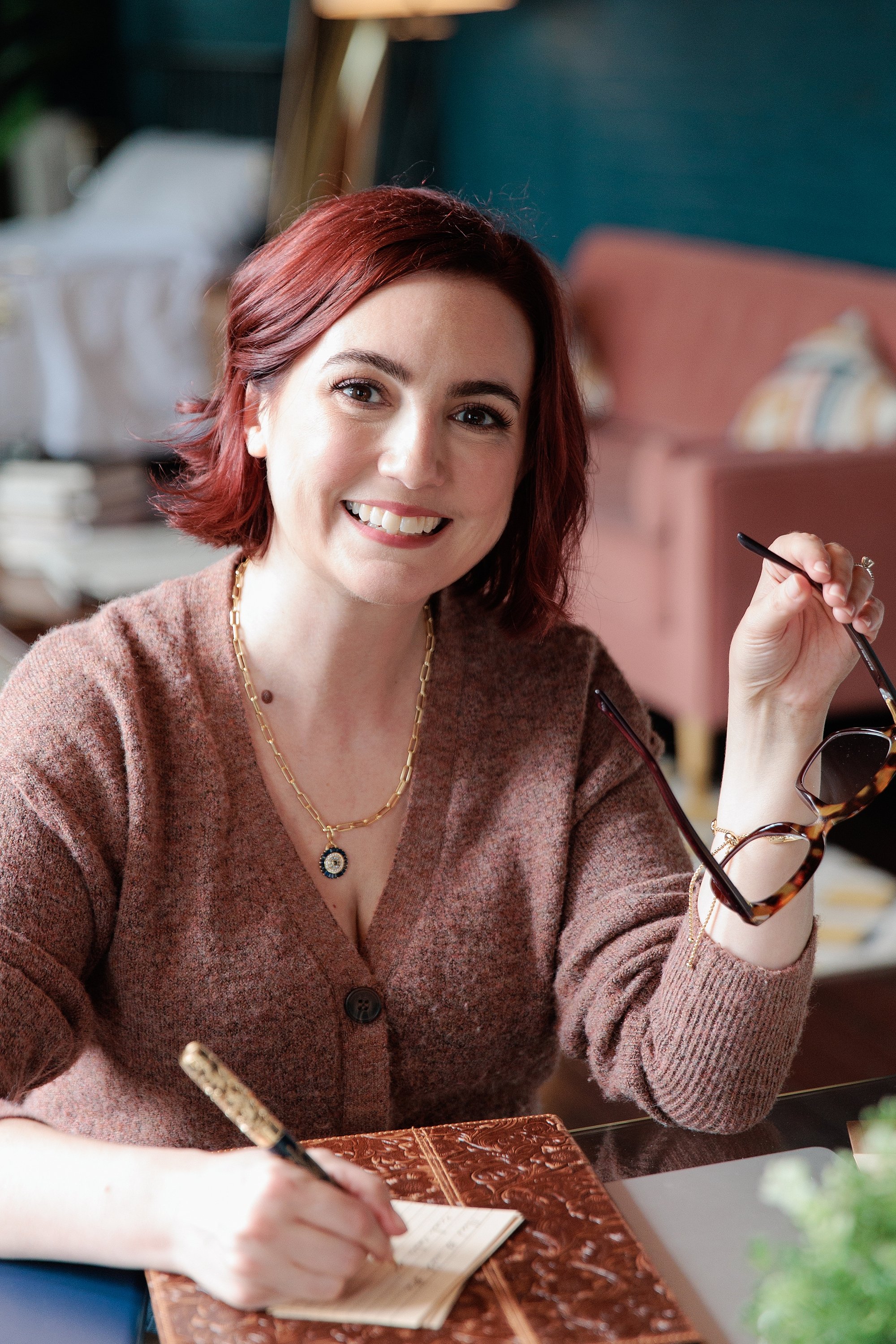 Jen writing at a table during her A Thinker's Guide branding session