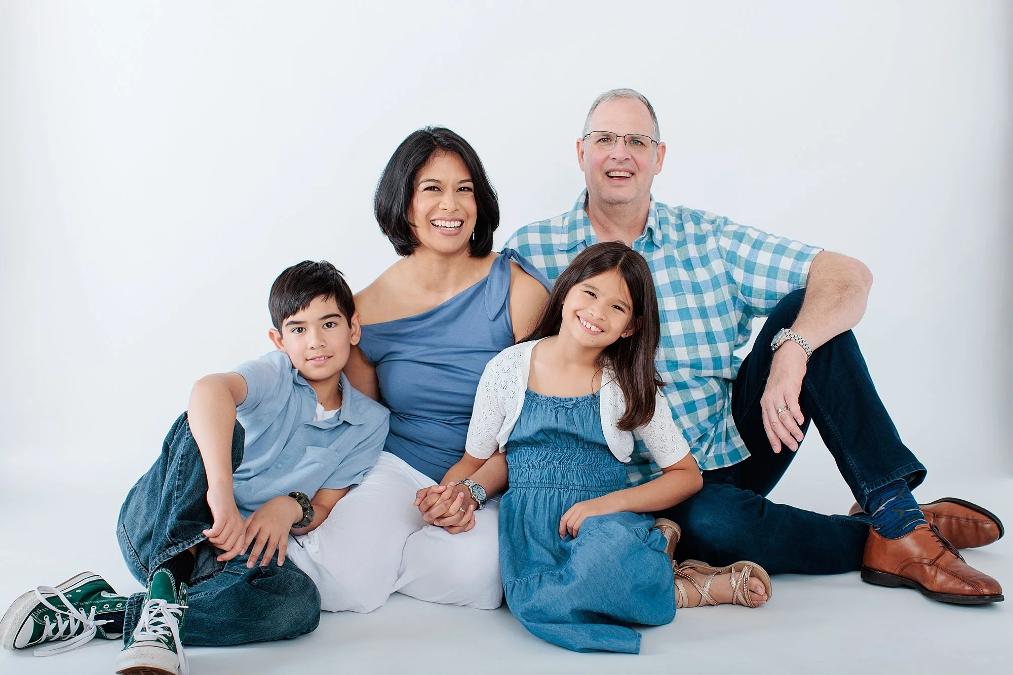 Family sitting on white background for studio session in Maryland