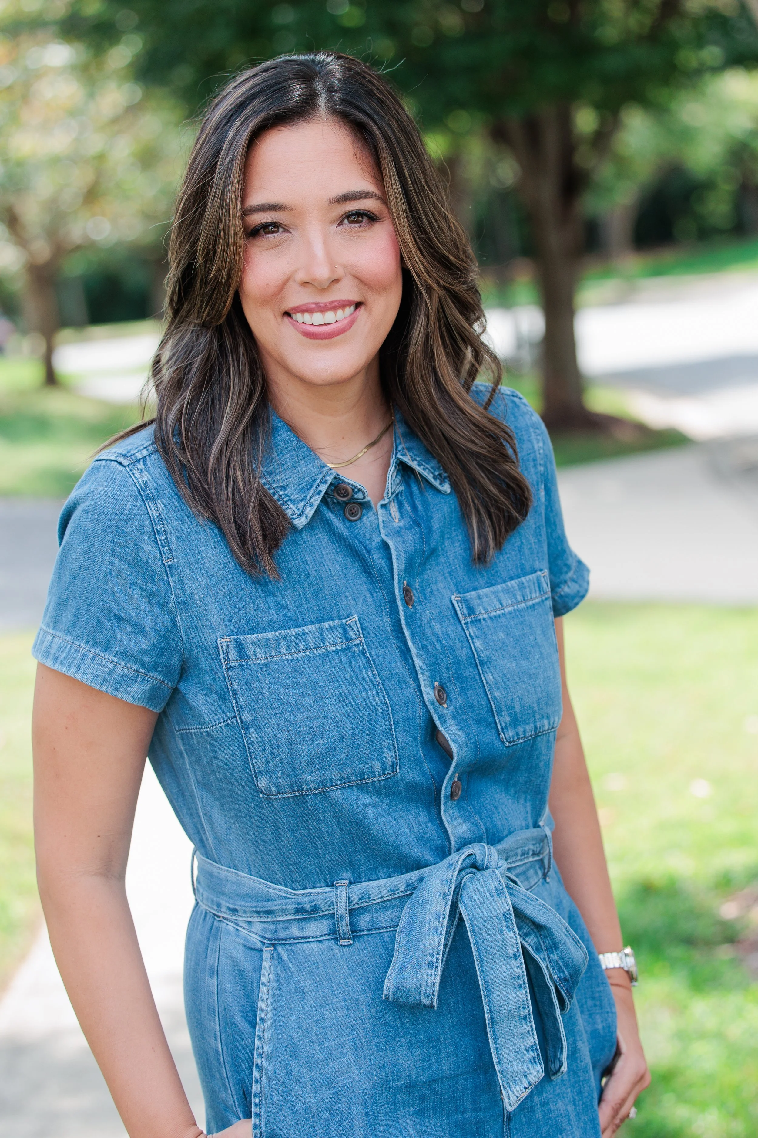 headshot of woman outdoors with green background