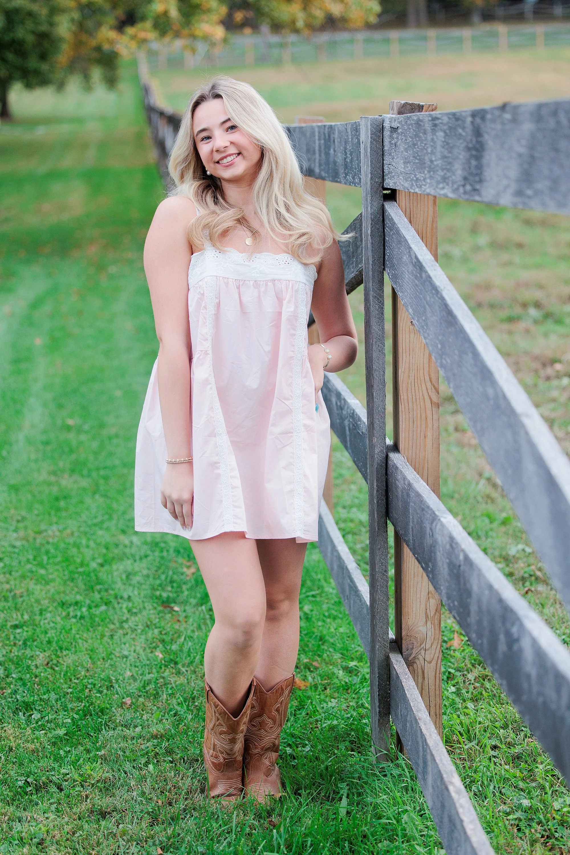 senior girl at fenceline during senior photo session