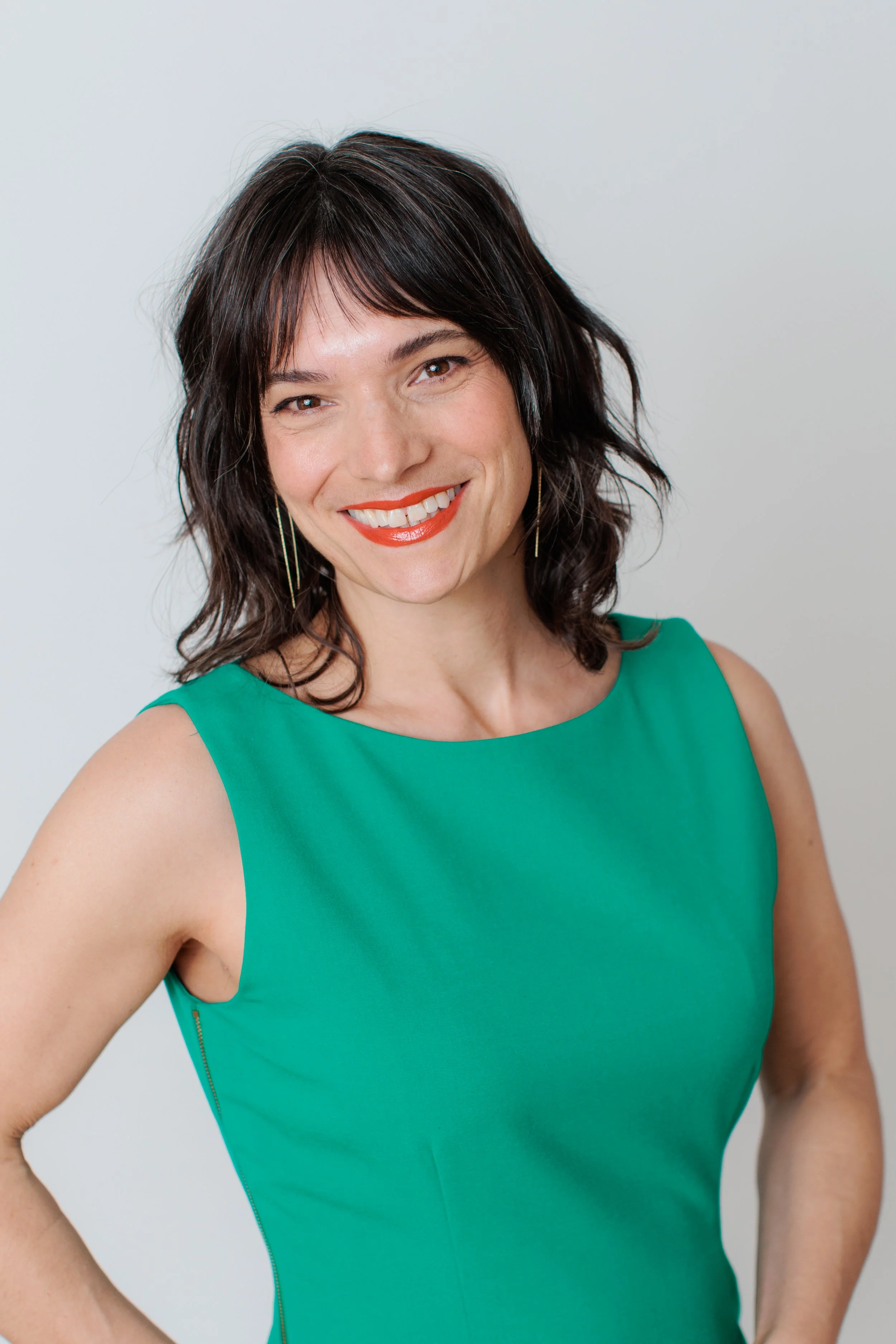 woman in green dress smiling at camera