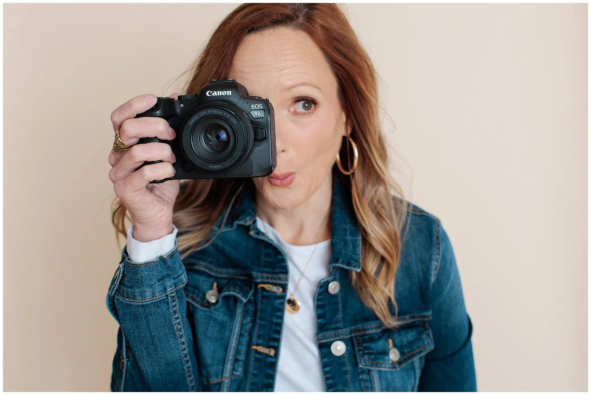 maryland photographer making a fun face while holding up her camera in Silver Spring studio