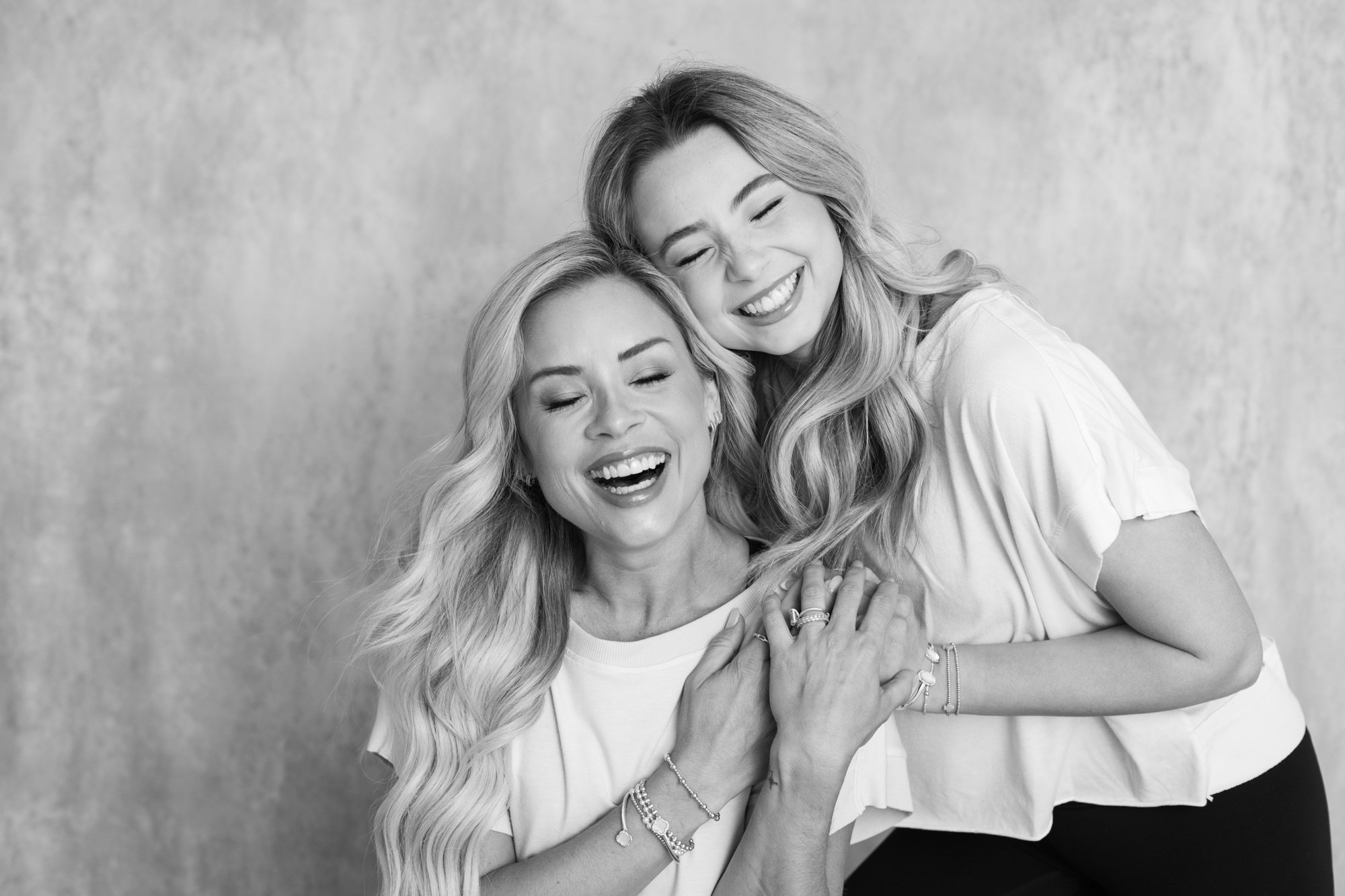black and white photo of mother and older daughter smiling and laughing