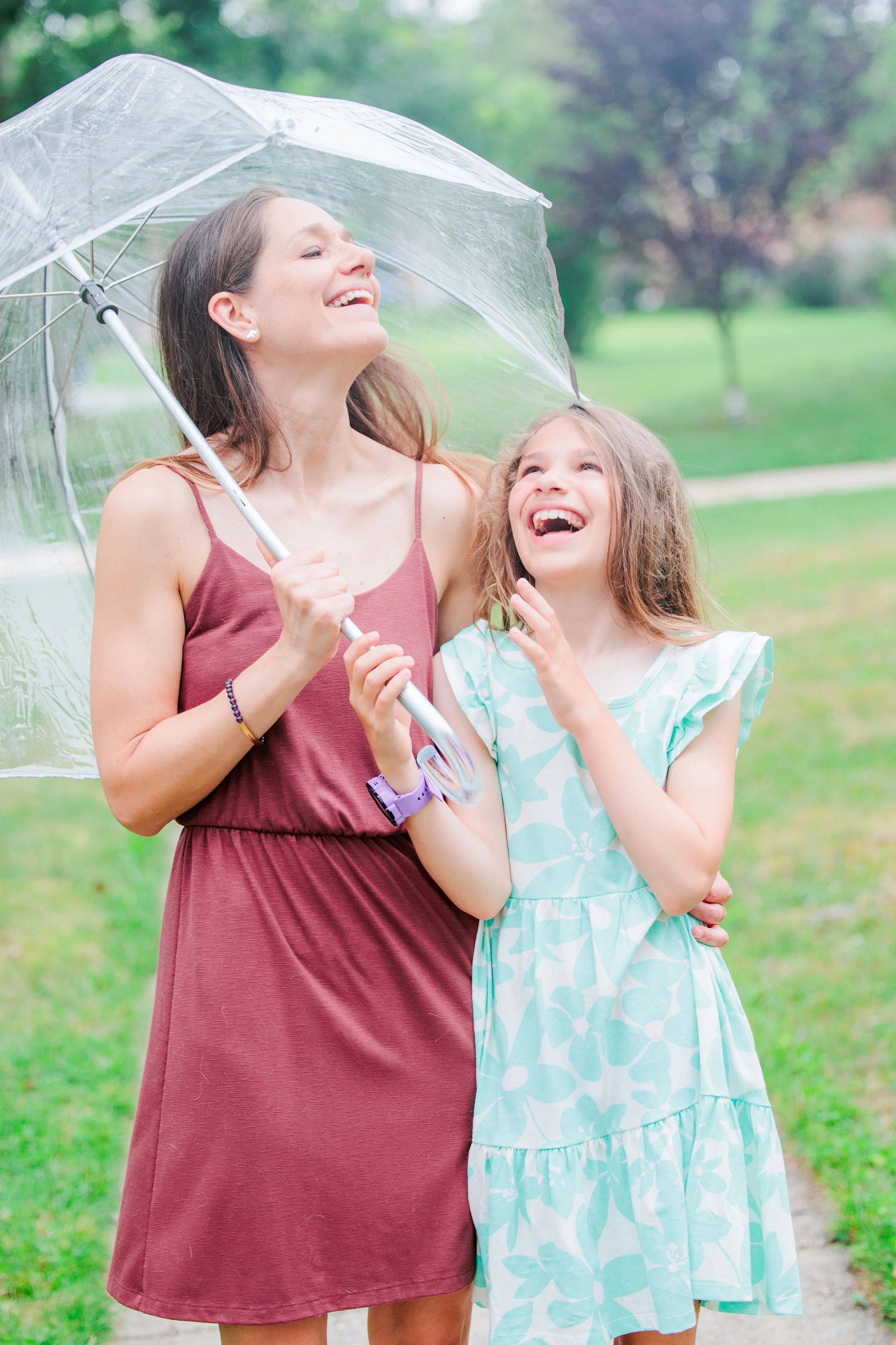mother and daughter under umbrella during rainy family photo session in Maryland