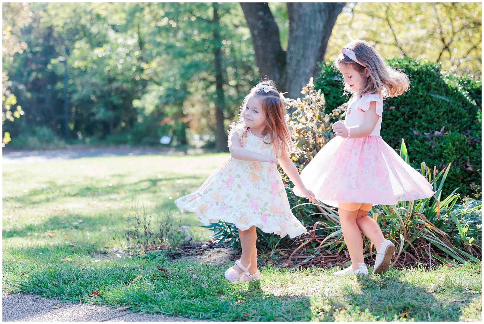 two sisters twirling in dresses for family photo session in Arlington VA